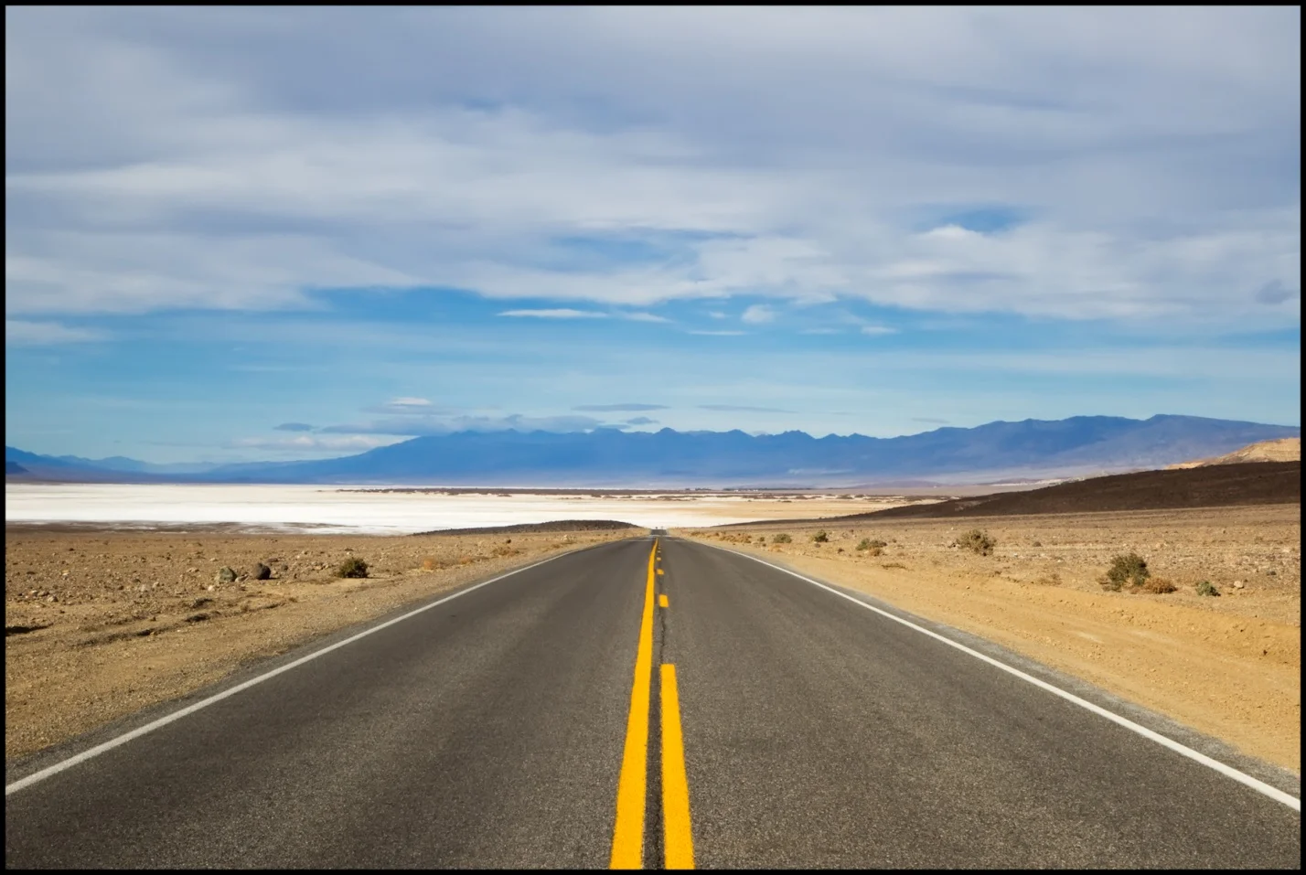 Asphalt roadway near the salt flats of Death Valley National Park in California