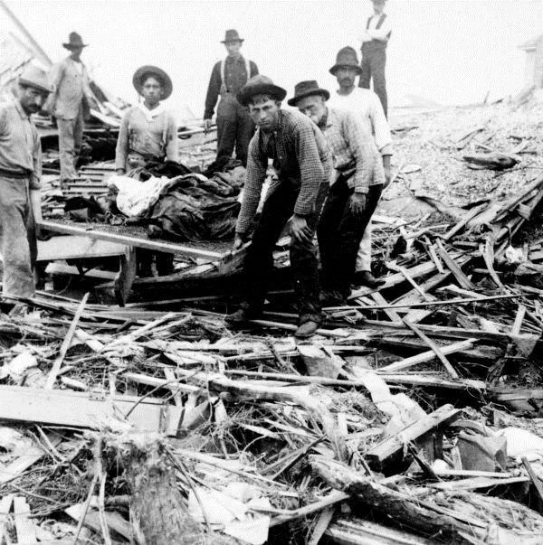 Survivors carry the dead out of the wreckage