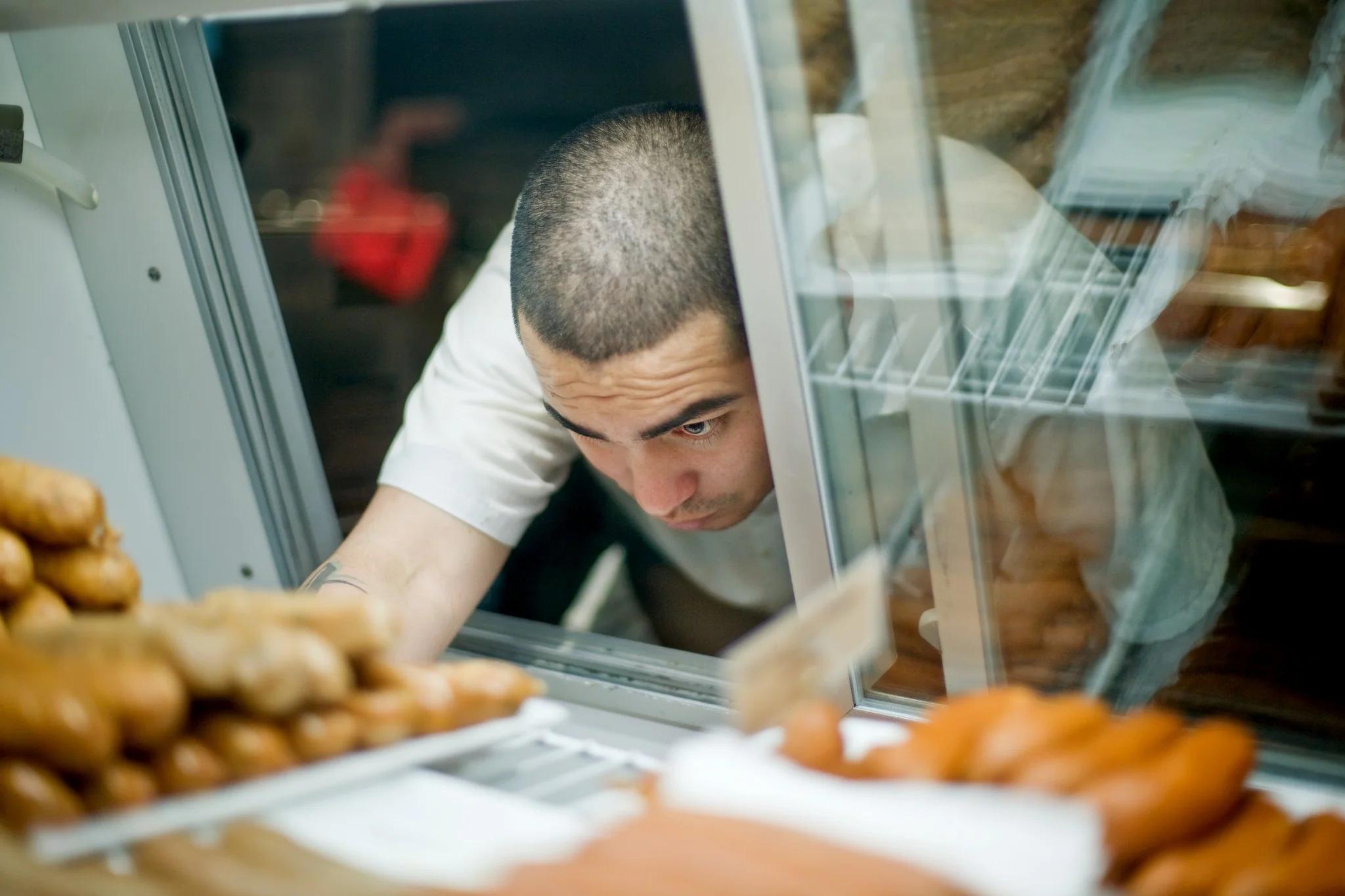 Employee reaching into sausage case