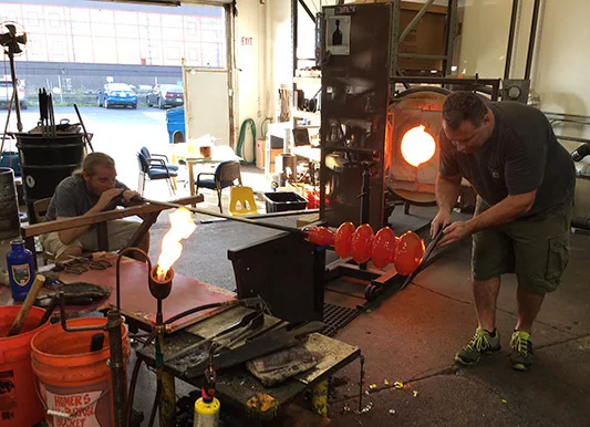 Mark Andrew and Guido Gerlitz of Effetto Glassworks blowing the Take Five.
