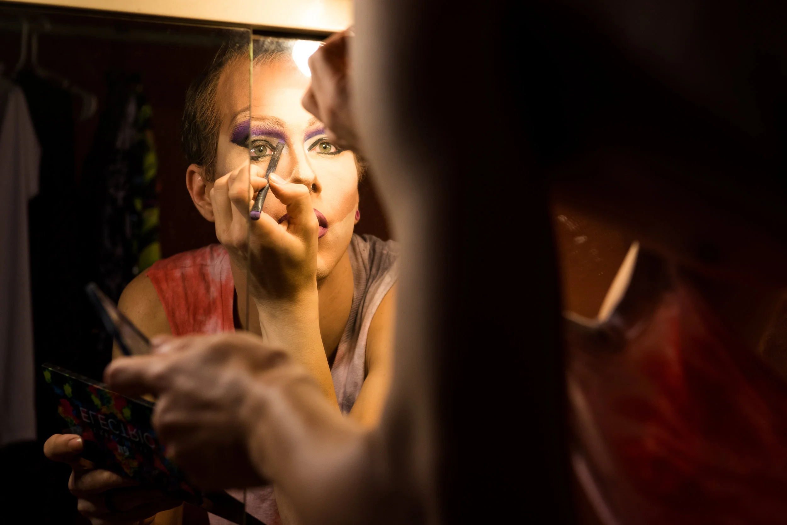 Lip syncing to the song "Look But Don't Touch" from the TV show "Empire," Koedam puts the finishing touches on his bright purple eyeshadow.