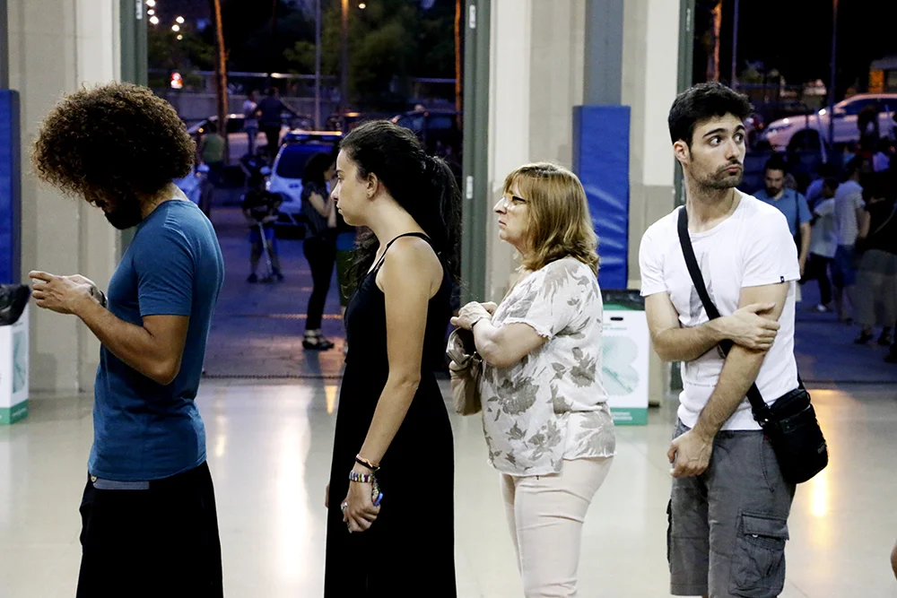 Participantes del mitin hacen fila en el ingreso del pabellón de la Estació Nord de Barcelona donde Podemos organizó un evento de ingreso libre para la espera de resultados.