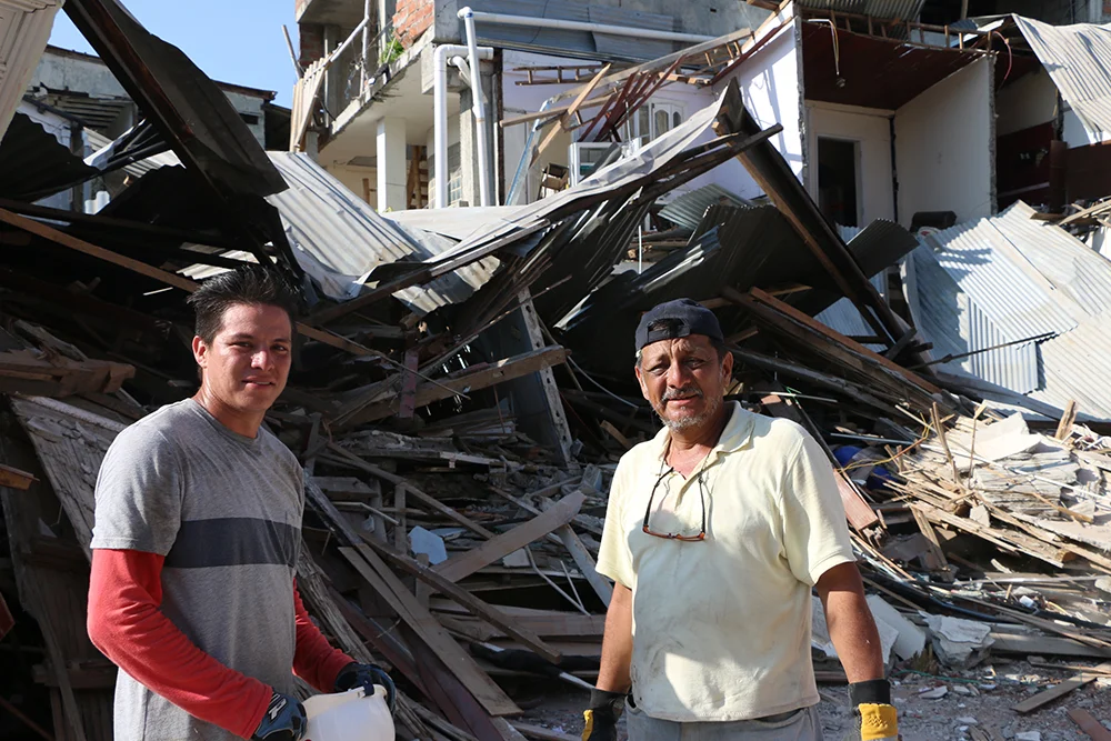 Santiago Ordóñez y su padre Jorge mueven escombros frente a los restos de su casa donde también funcionaba su local comercial. La vivienda tenia 130 años y era considerada patrimonio de Bahía | Foto: M. Ayala