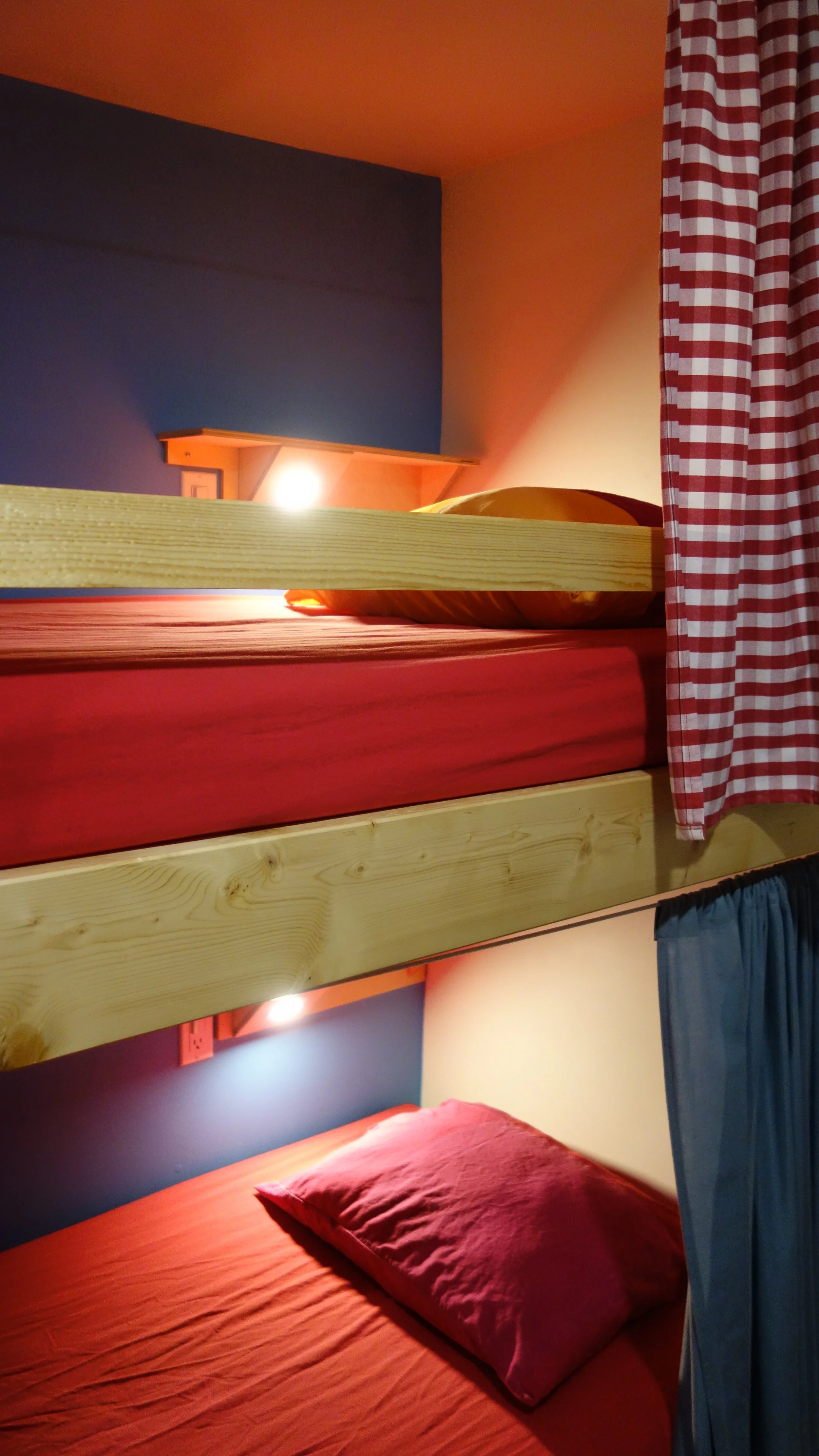 dorm beds with privacy curtains, shelves and reading light