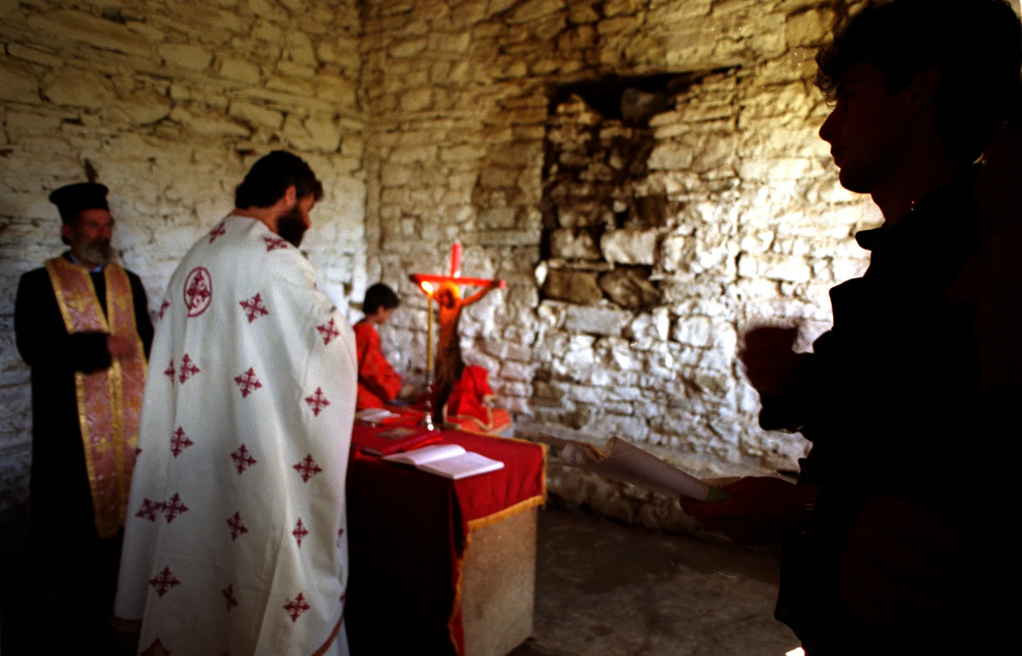 The villagers of Jeronisht, listen as Rev. Martin Ritsi, an orthodox priest from Orange County, celebrates their first liturgy in 29 years in St. Martin's Church. The walls are bare, as religious icons were confiscated years ago by the government.©Gail Fisher Los Angeles Times