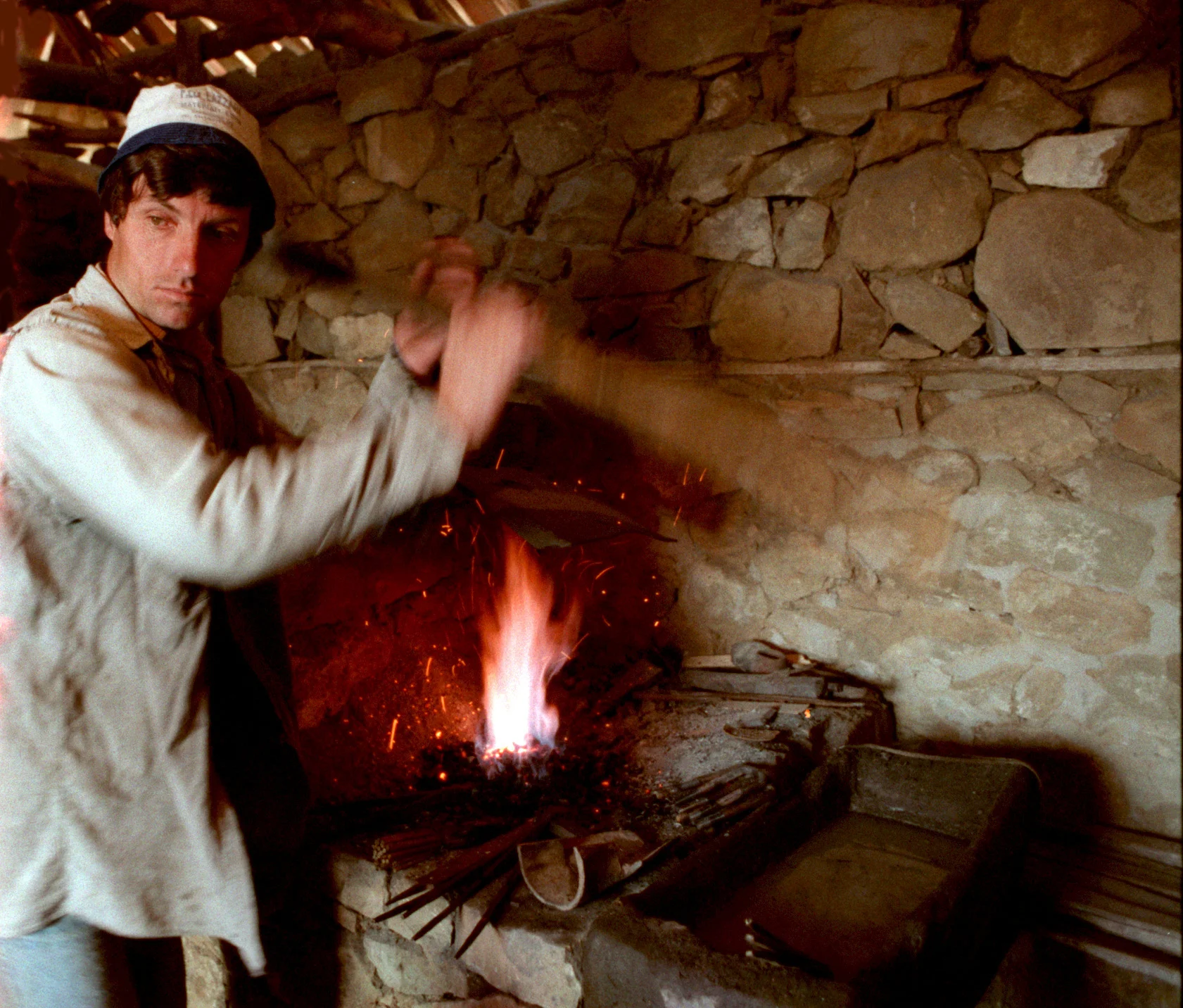 Blacksmith Tomorr Halili works in his newly opened forge where he uses a primitive furnace, a sledgehammer, an anvil and other simple tools to repair his neighbors' farm equipment. ©Gail Fisher Los Angeles Times