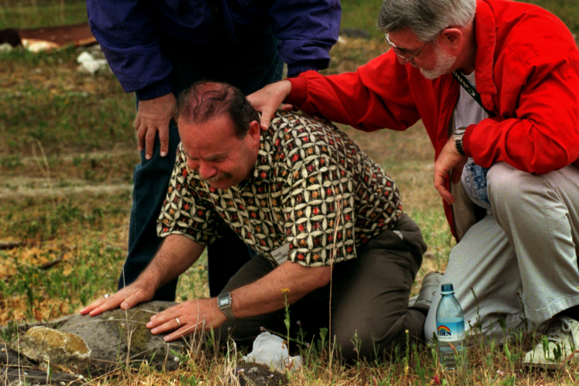  Haithan Bundakji, center, Muslim leader of Orange County Interfaith group, cries for the loss of two brothers killed years earlier in the Israeli conflict. Rev. Bob Shepard,&nbsp; right, and Rabi Bernard King, show their support in the Muslim cemete