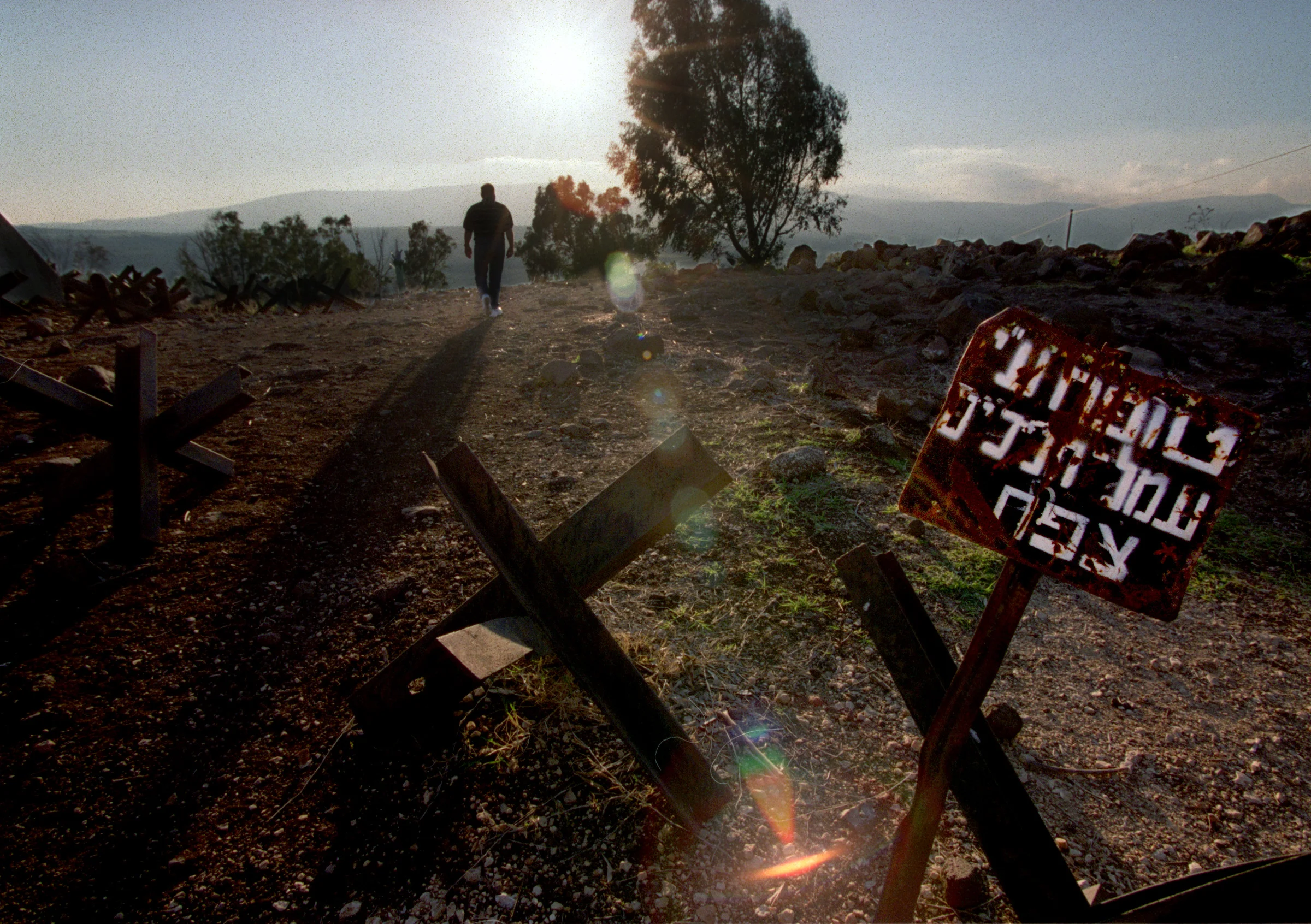 Haithan Bundakji ascends to a memorial in Golan Heights, the stronghold of the Syrians until 1967. Nearly all of the landscape bordering the road throughout this area is lined with barb wire and thousands of land mine markings. ©Gail Fisher Los Angeles Times