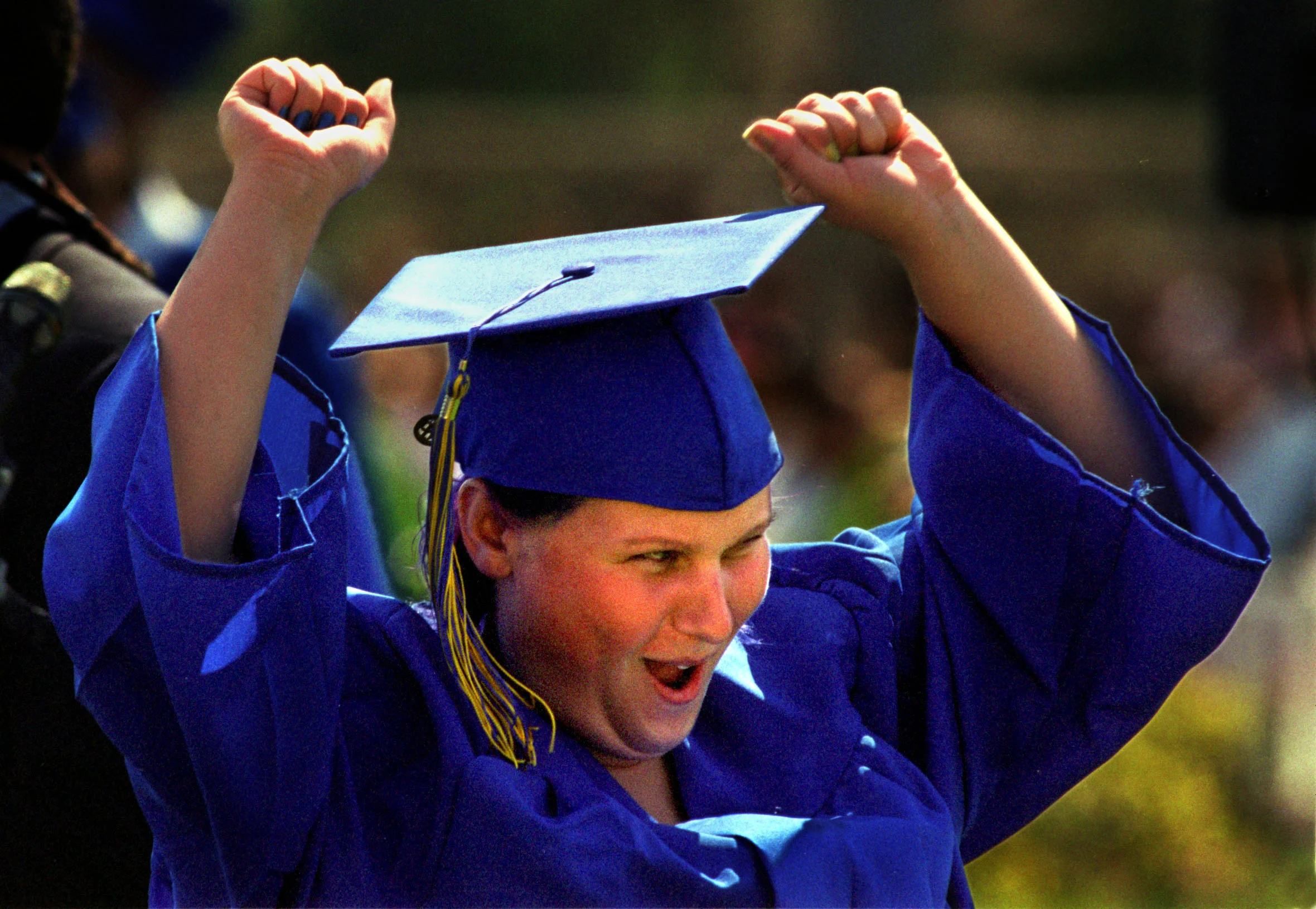 After ricocheting through a dozen foster homes over the past six years, including a detour to a Utah home for disturbed girls, Janea's life as a foster child ends today. Purple hair and tattoos hidden beneath her cap and gown, she beams with pride as she graduates from LA Quinta High School, Class of 2001. ©Gail Fisher Los Angeles Times 