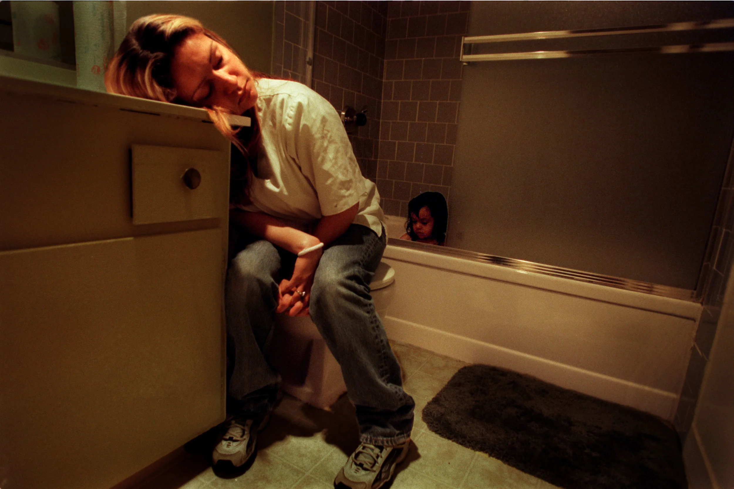 After a long day of working and riding buses all over town, Monique Luna closes her eyes in sheer exhaustion as Lyla plays in the bath. "I leave her in the bathtub a little bit longer so she can play and get more tired so she won't try to fight me. I try to do little tricks so I won't seem as tired as I really am," says Monique. ©Gail Fisher Los Angeles Times 