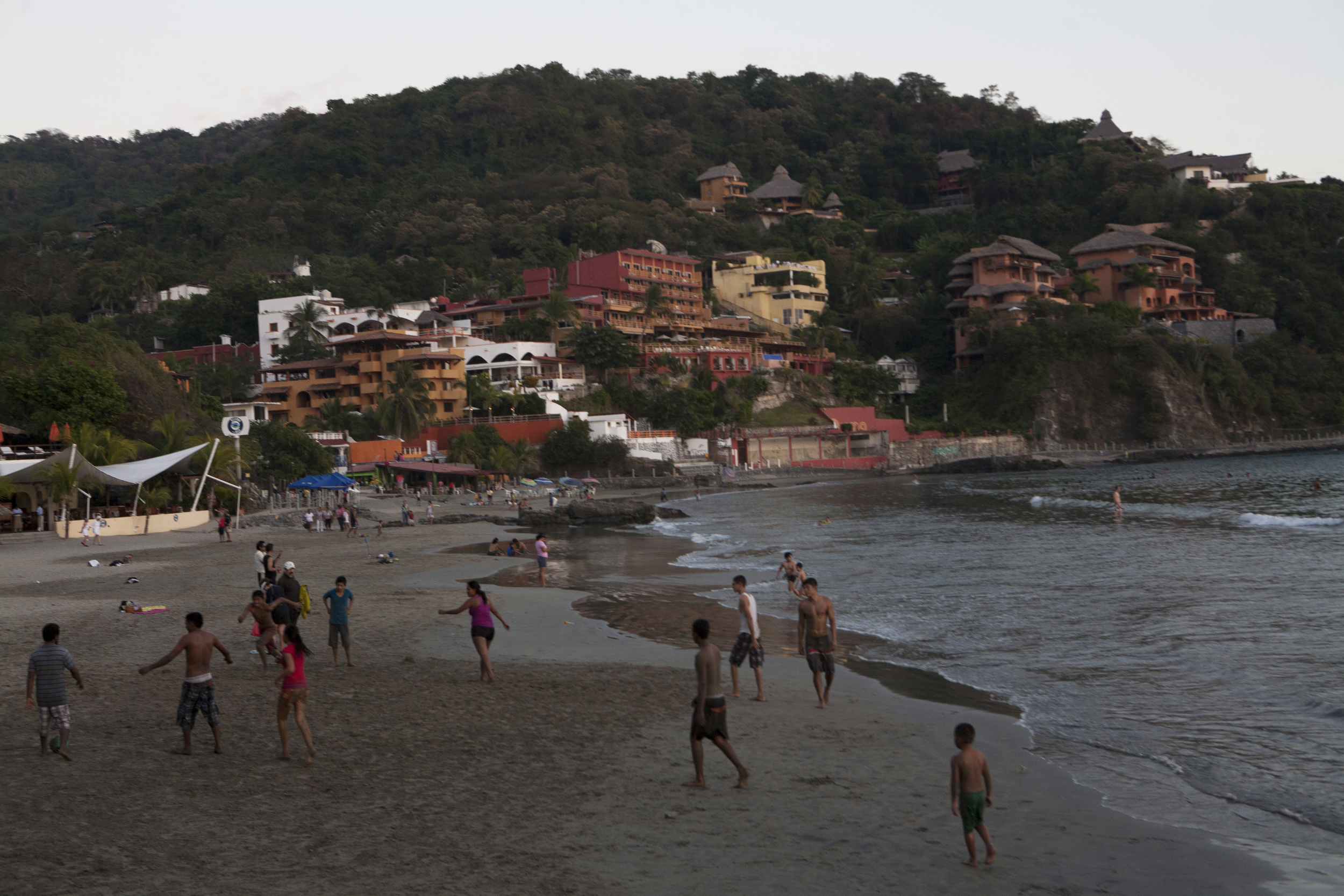  The locals enjoy an evening at Playa La Madera, (Wood Beach), a half mile stretch of sand where humble family eateries, restaurants, bungalows and hotels dot the cement and sand walkway. ©Gail Fisher&nbsp; 