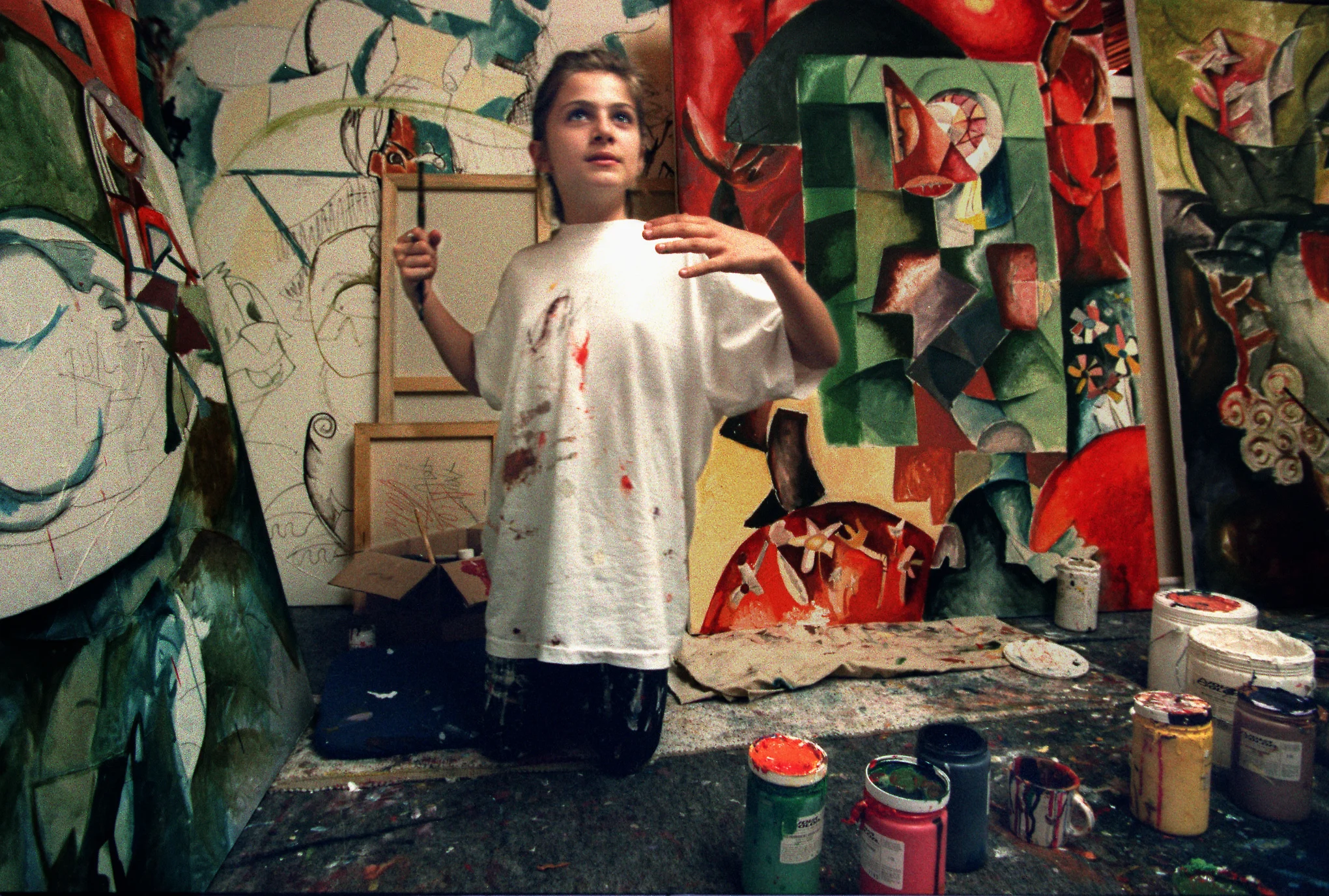 Alexandra paints while surrounded by her works-in-progress in the family room-cum-art studio of the Nechita 's modest Norwalk home. Within nine months, she's had 16 solo exhibits of her paintings, at least $1.5 million in sales. Today, most of her paintings sell for between $30,000 and $60,000, although one just sold for $80,000. ©Gail Fisher Los Angeles Times