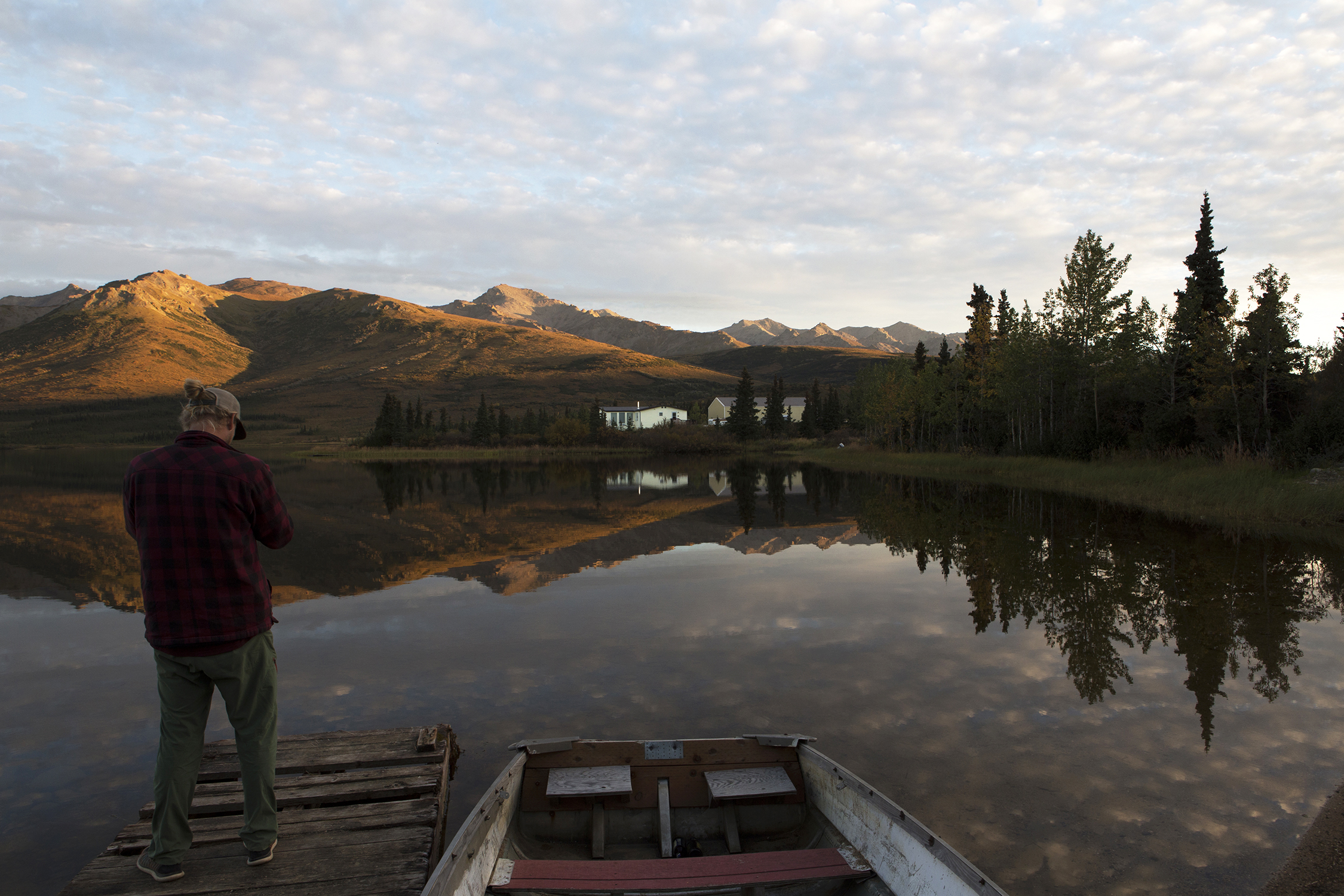  Zachary Patton from southern California, working in Healy, Alaska, enjoys the beauty of the late evening setting sun as it turns the surrounding hillsides a golden hue over Otto Lake. © Photo by Gail Fisher 