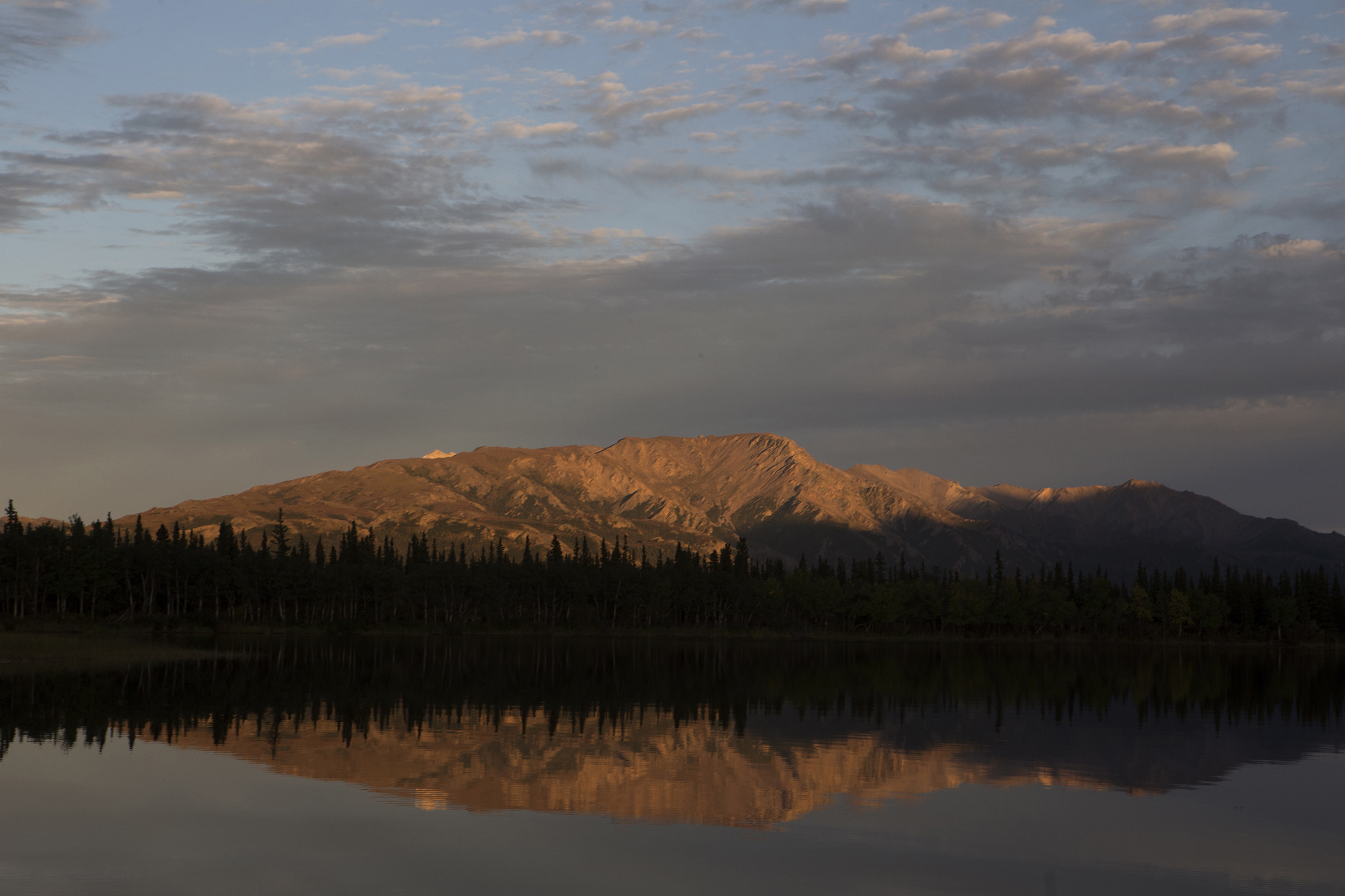  Sun sets over tranquil Otto Lake with views of Mt. Healy and Mt. Dora as a backdrop in Healy, Alaska, ten miles north of north of Denali National Park and Preserve. © Photo by Gail Fisher 