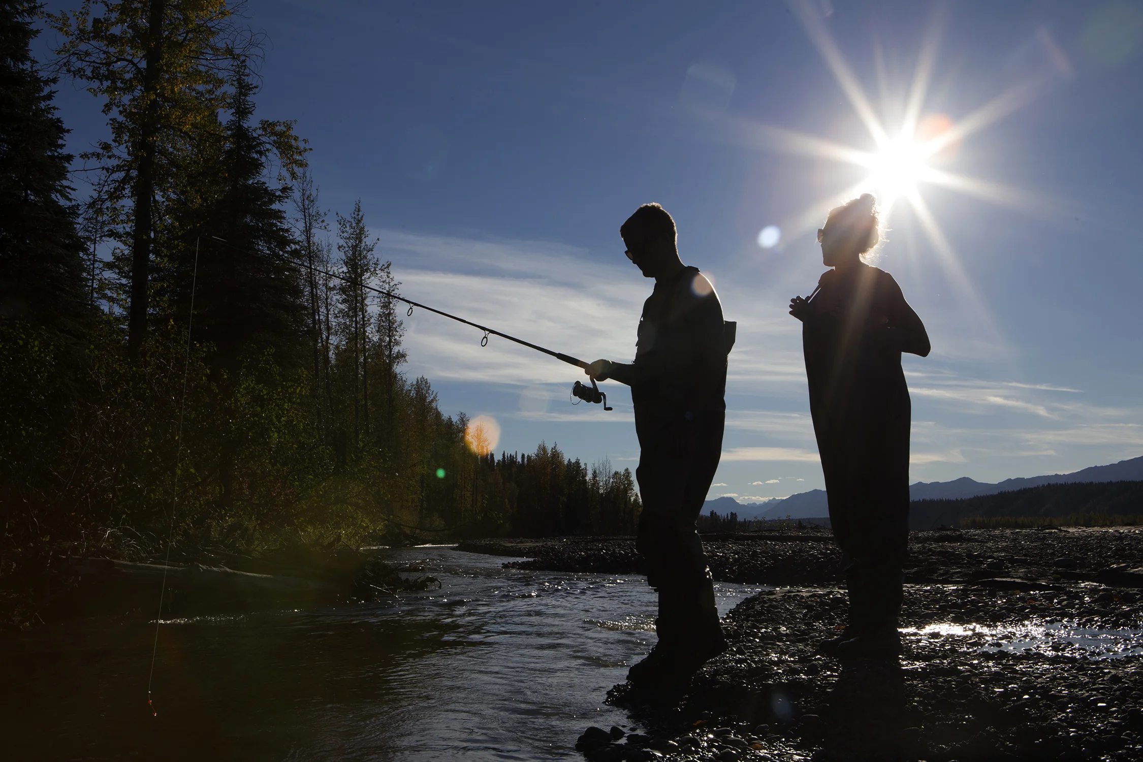 Austin and Whitney Krempin from southern California enjoy an afternoon in autumn fishing while wading through glacial streams outside Talkeetna, Alaska. © Photo by Gail Fisher