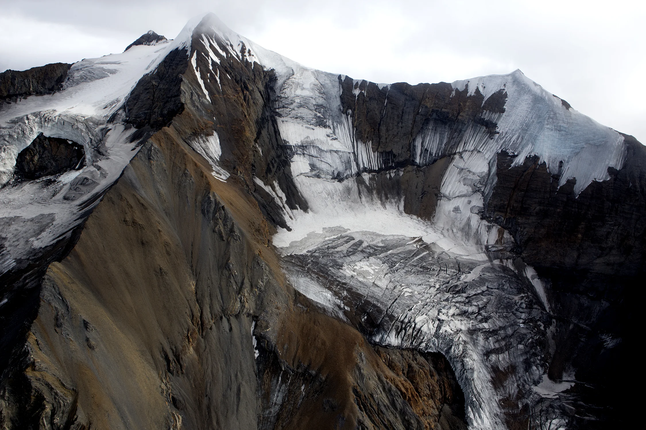 Large amounts of rock debris are carried on, in, and beneath the ice as the glaciers move downslope in the Alaska Range. © Photo by Gail Fisher