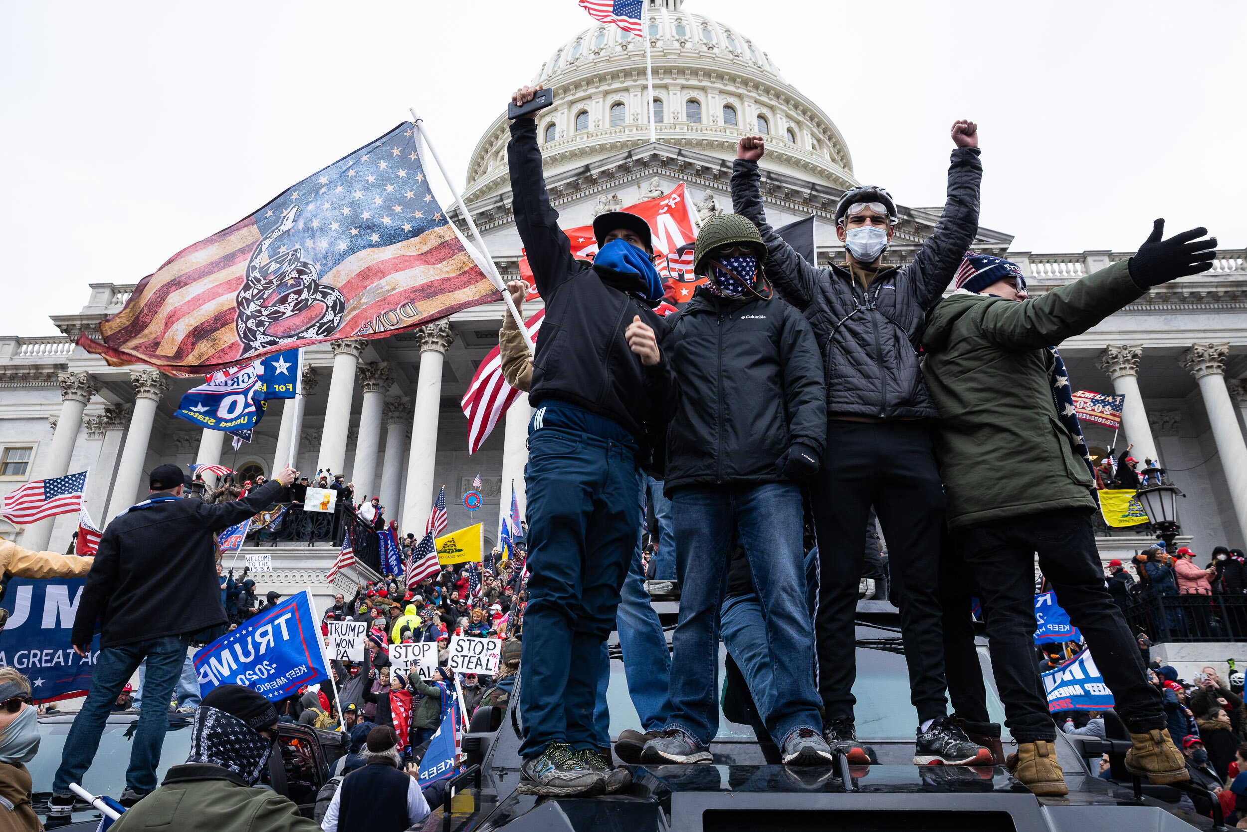  Trump supporters stand atop police vehicles and occupy the U.S. Capitol steps after breaching the security perimeter during the Jan. 6, 2021 insurrection. 