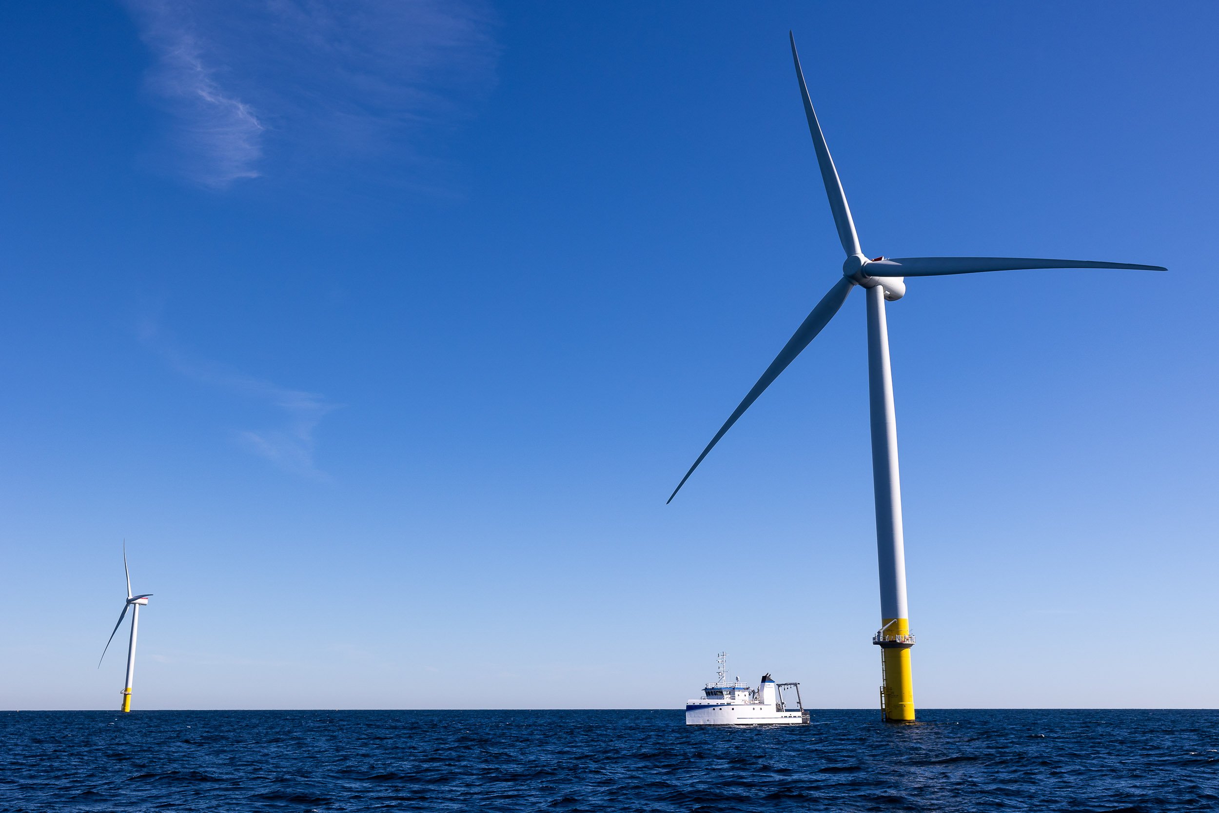  The Coastal Virginia Offshore Wind pilot turbines are seen off the coast of Virginia Beach Sept. 27, 2021. Also seen is the Virginia Institute of Marine Science’s flagship vessel, the R/V Virginia. 