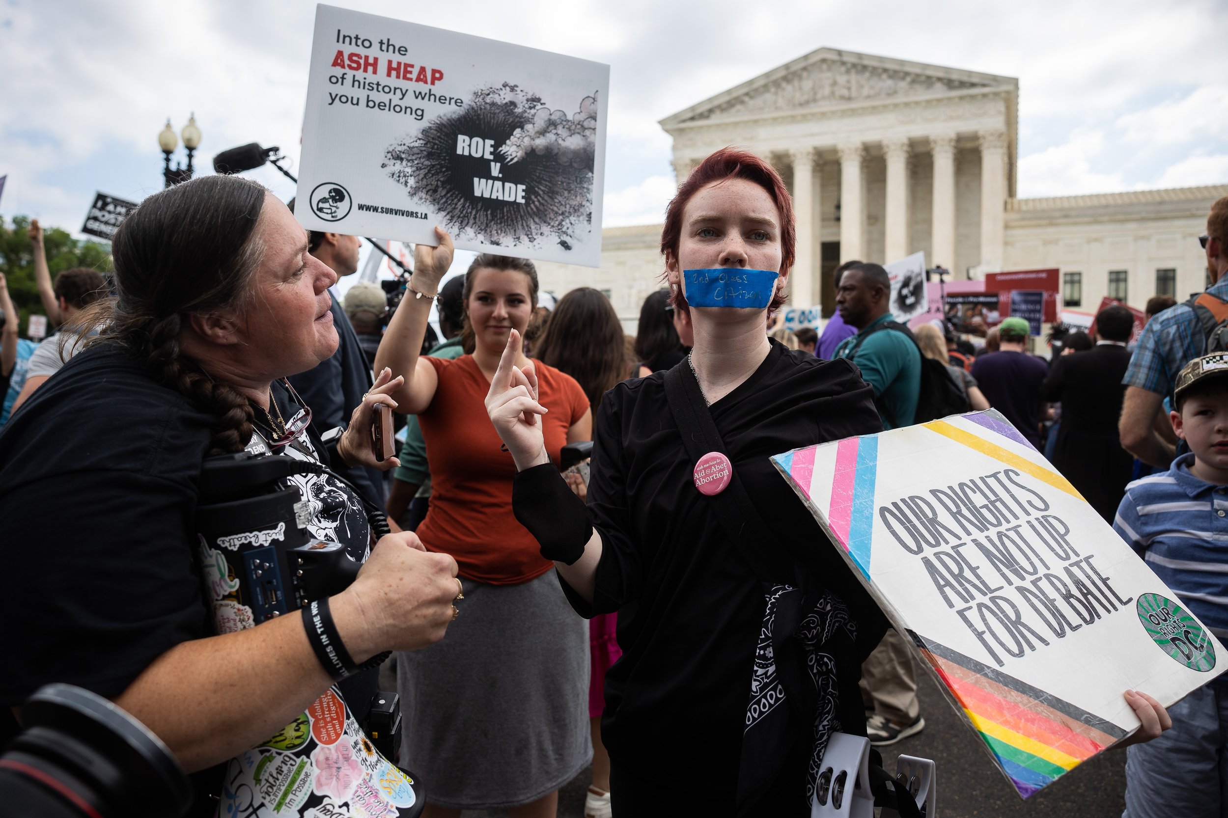  Anti-abortion demonstrator JC HalleluYah Carpenter, at left, clashes with abortion-rights advocate Sadie Kuhns outside the U.S. Supreme Court after the court announced its decision in Dobbs v. Jackson June 24, 2022.  