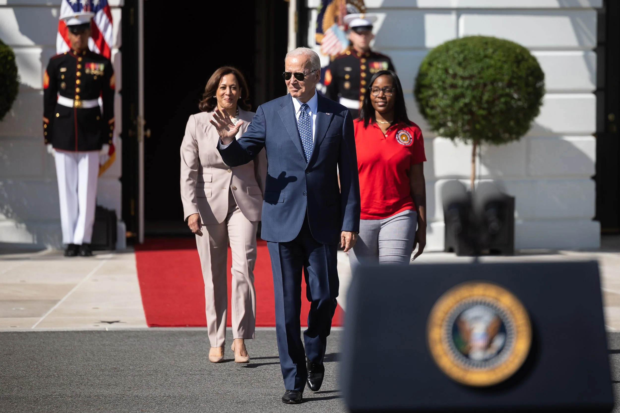  President Joe Biden, flanked by Vice President Kamala Harris and International Brotherhood of Electrical Workers Local 103 electrical apprentice Lovette Jacobs, arrives for a celebration of the recently signed Inflation Reduction Act on the South La