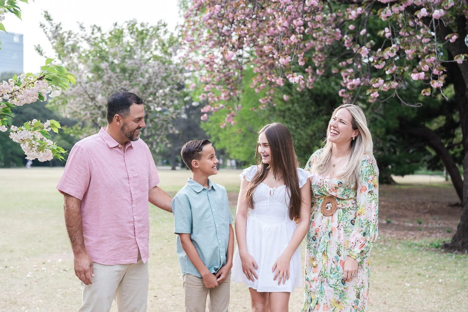 Candid shot of family laughing while enjoying the stunning sakura scenery in Shinjuku Gyoen National Park