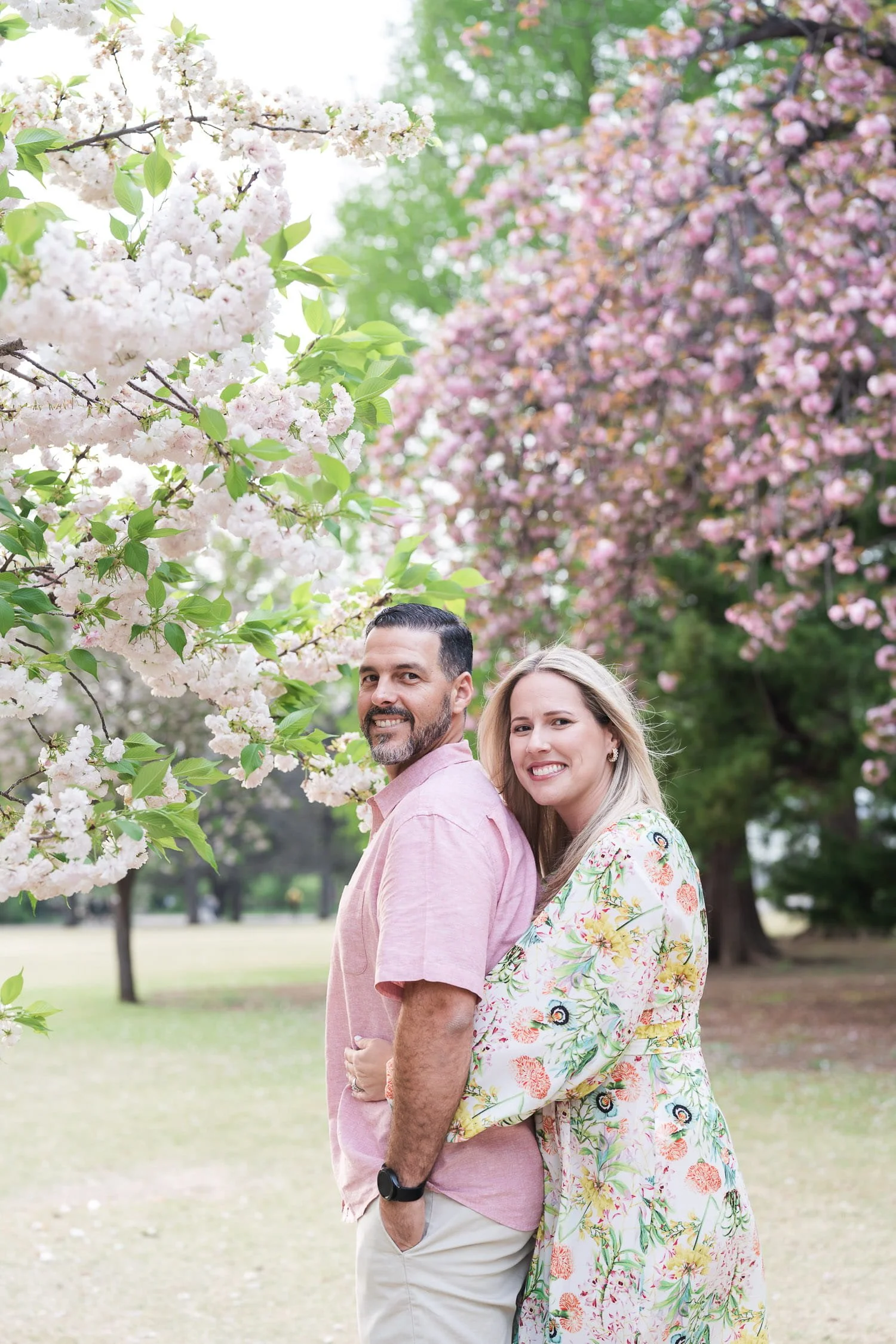 Couple shot under white and pink cherry blossom trees during our family photoshoot