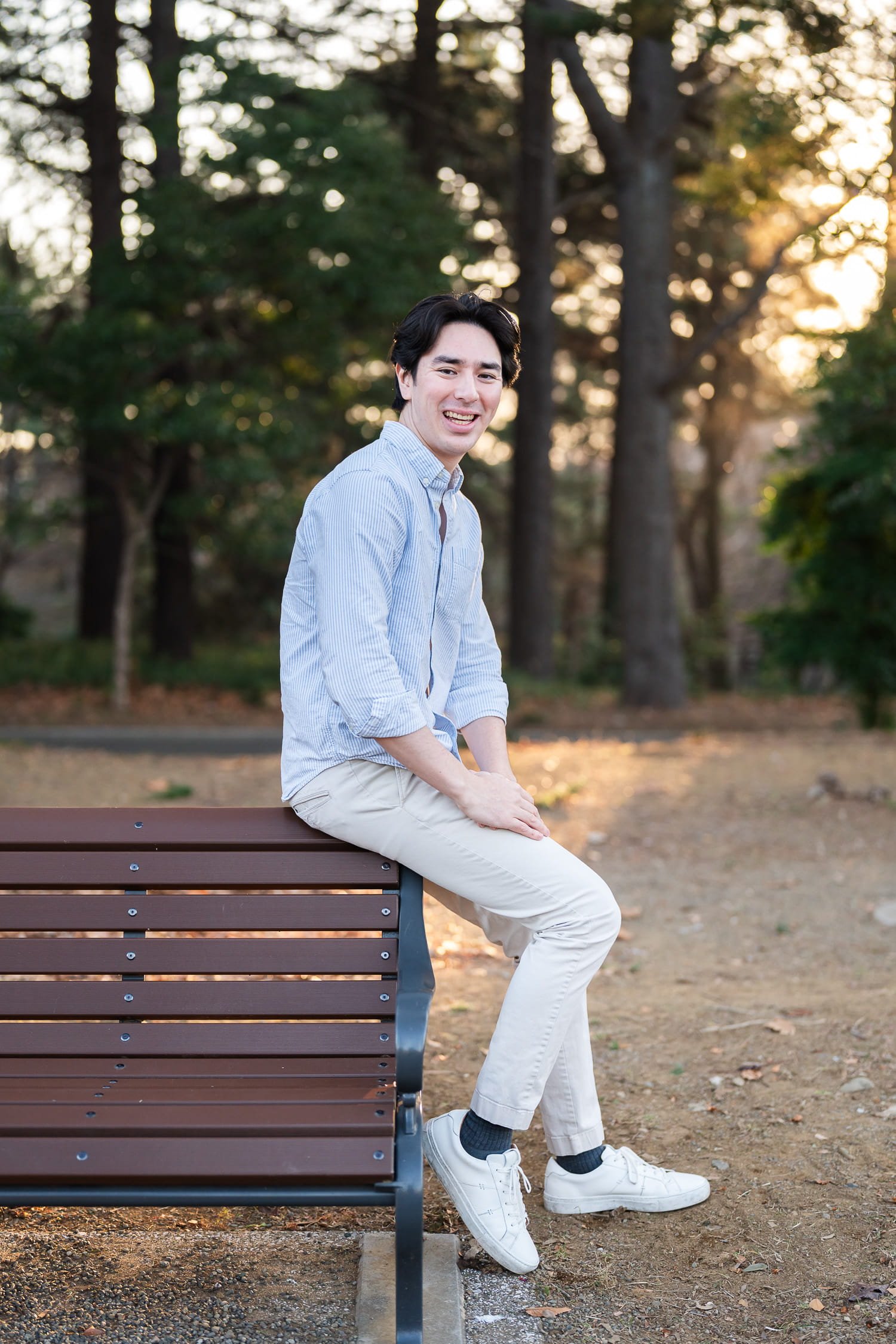 Solo traveler to Tokyo sitting on a bench posing for a full-body shot in Shinjuku Gyoen