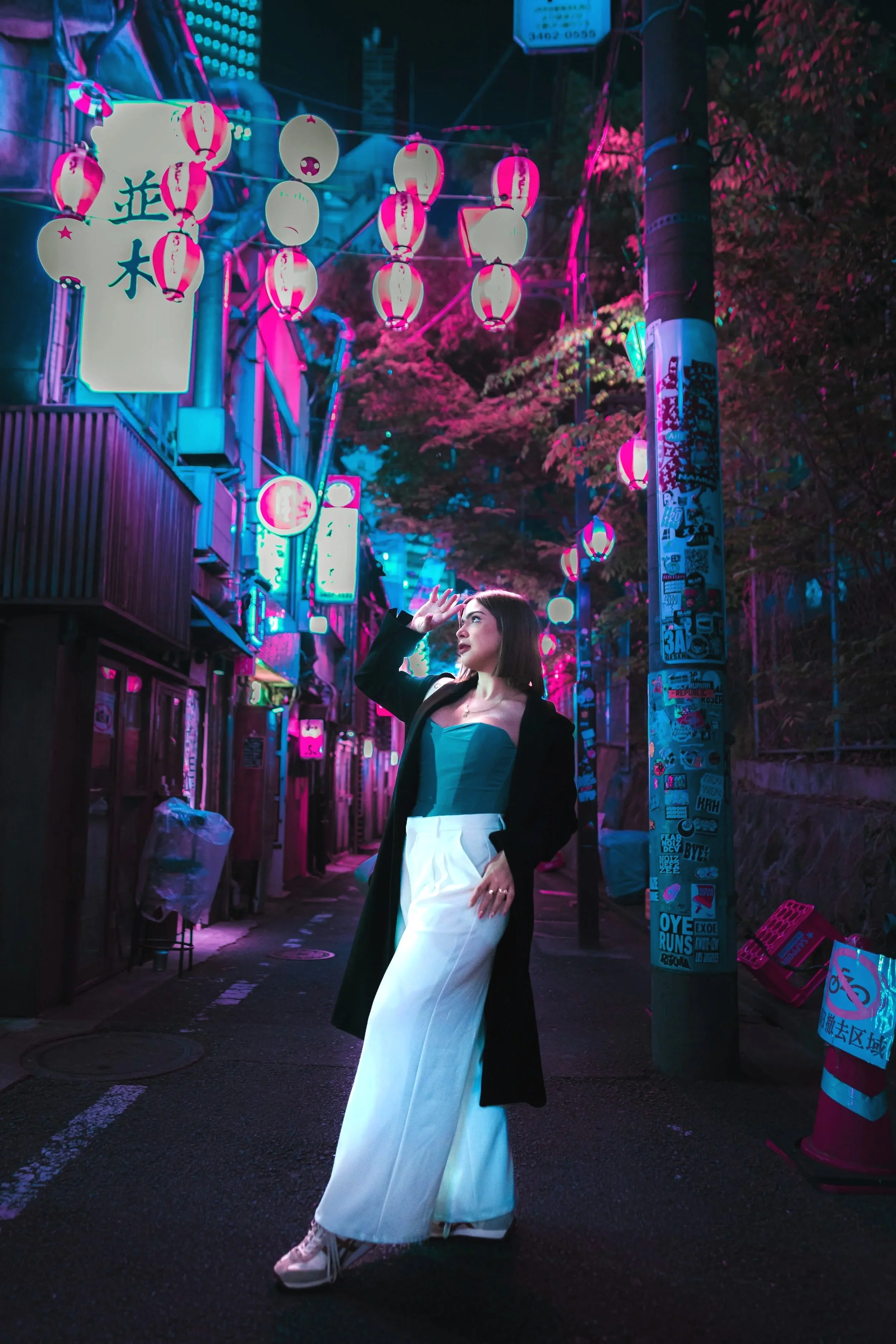 Female solo traveler posing elegantly at Shibuya Nombei Yokocho surrounded by cyberpunk pink and turquoise lanterns and ambient lights