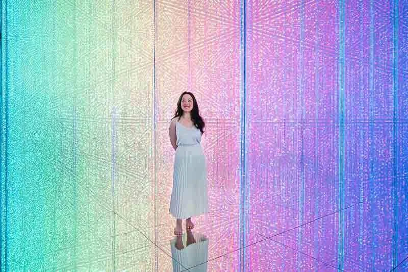 Solo female traveler exploring immersive digital art at teamLab Borderless Tokyo