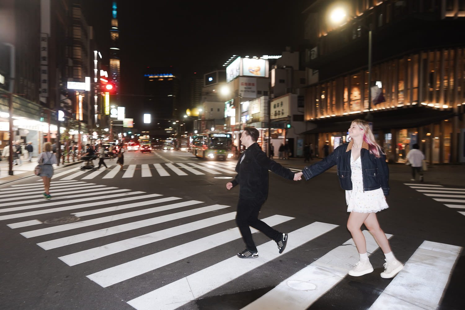 The couple ran as they were crossing the road in front of Asakusa Kaminarimon Gate with Tokyo Sky Tree in the background