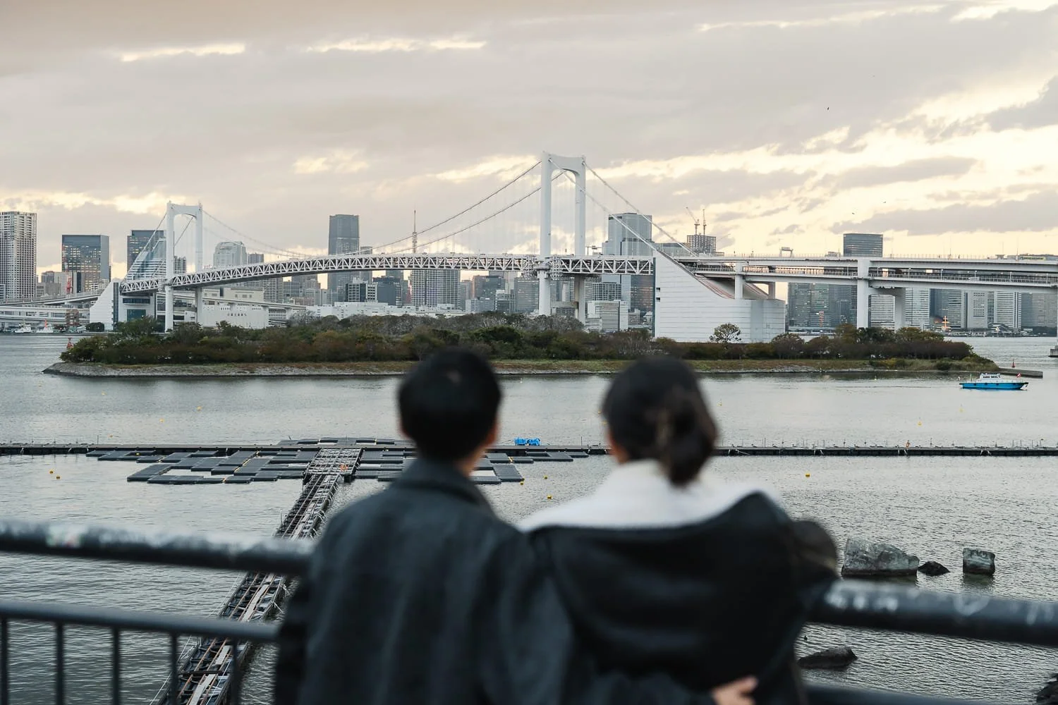 Couple looking at Rainbow Bridge in Odaiba during a sunset