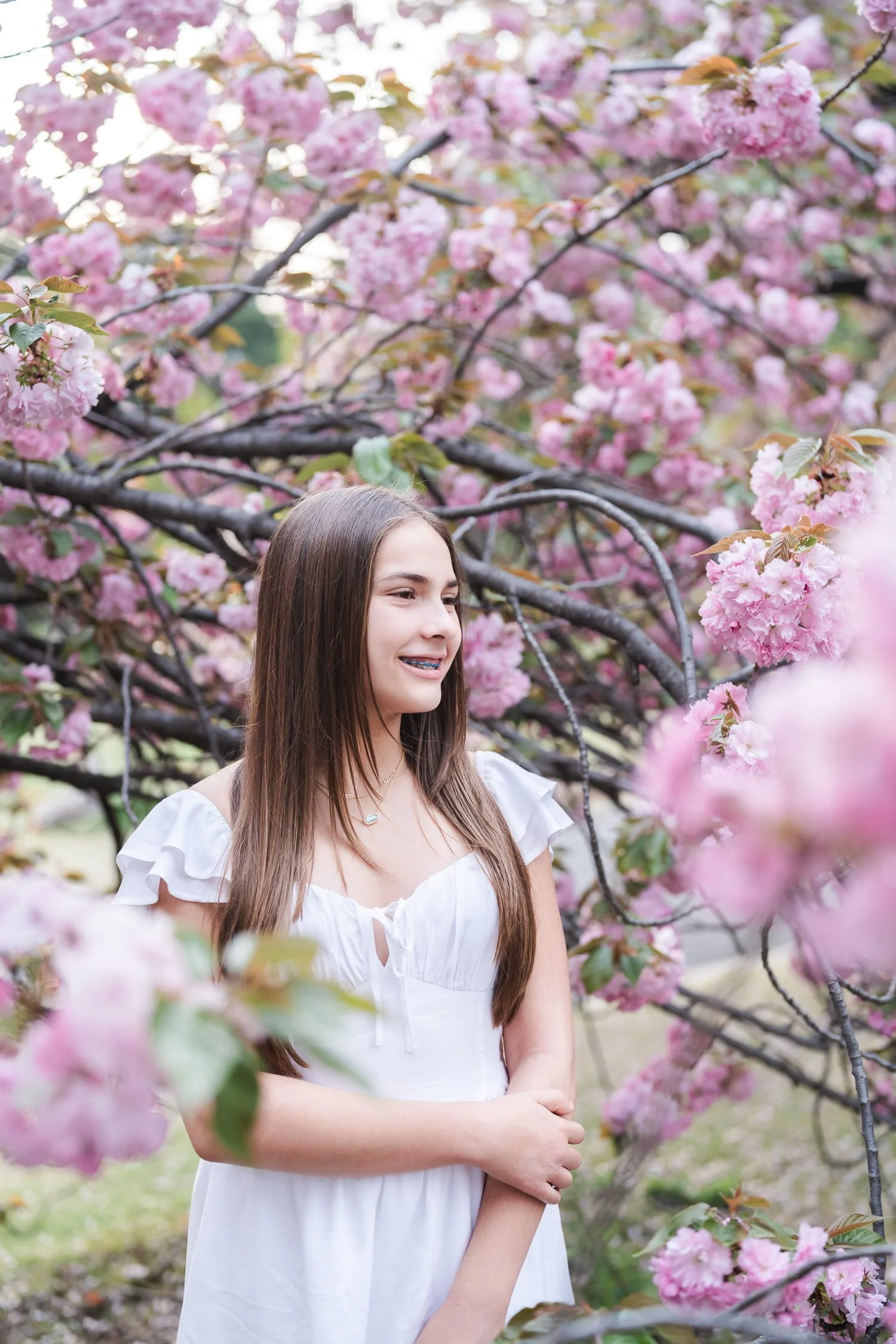 Portrait of Jeffrey's daughter, she smiles while being surrounded by stunning sakura flowers