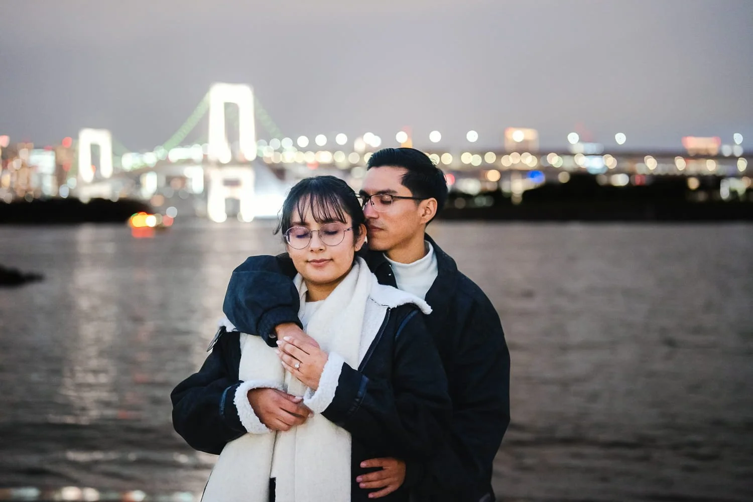 An intimate moment where couple embracing each other on the beach in front of Rainbow Bridge