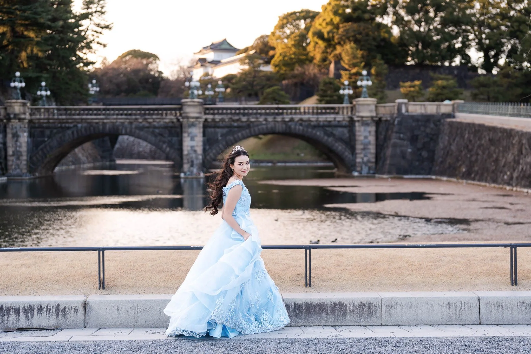 uinceañera in a light blue gown walking beside the moat near Nijubashi Bridge at the Tokyo Imperial Palace