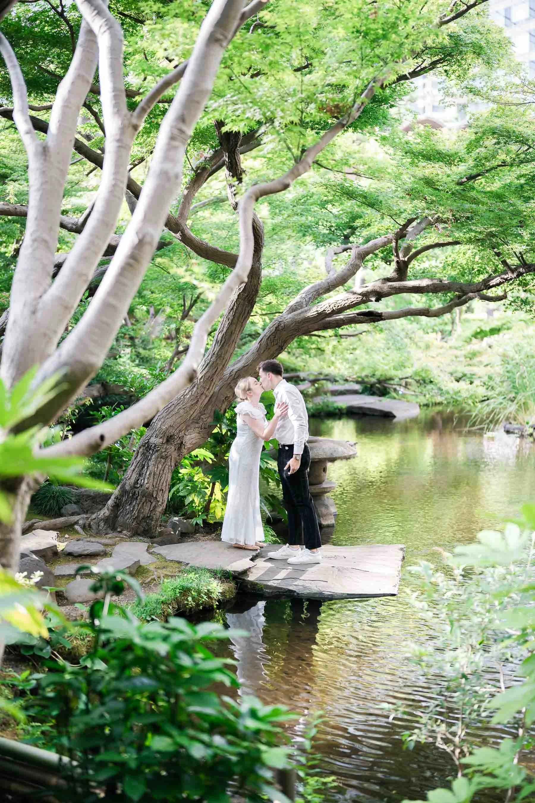 Couple kissing after engagement in private Tokyo garden