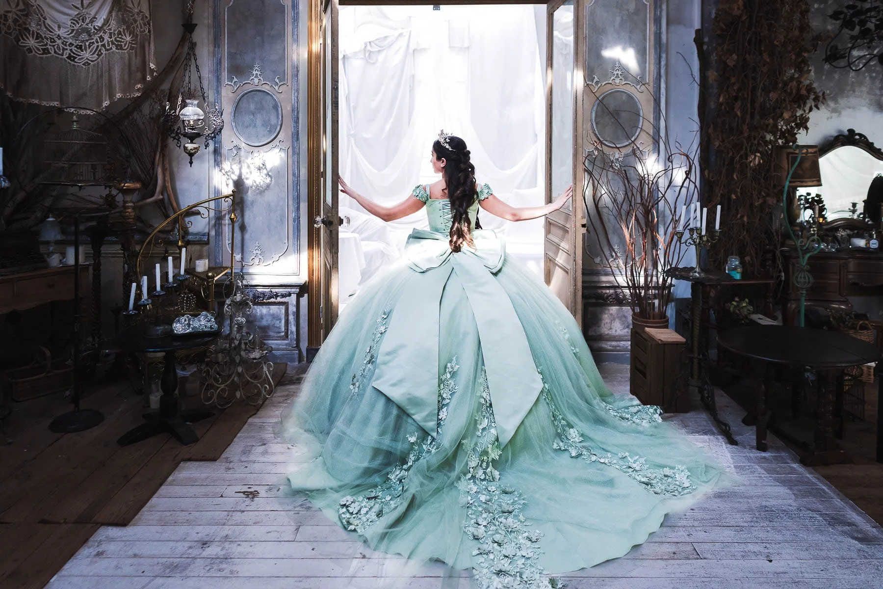 Quinceañera in a mint green ball gown with a full train walking through a vintage-styled studio doorway, Tokyo photoshoot