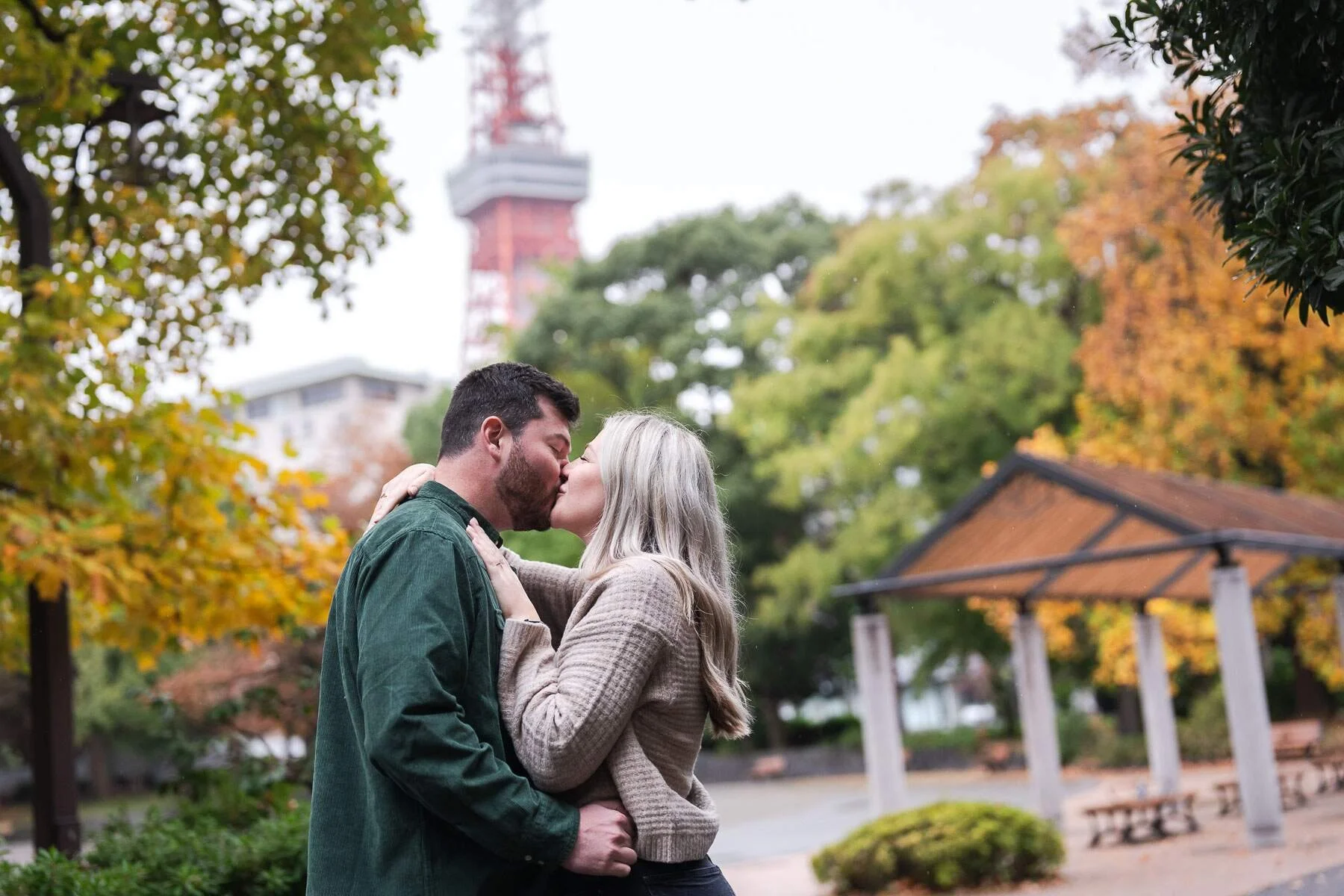 Couple kissing as they celebrate the successful surprise proposal in Shiba Park , Tokyo