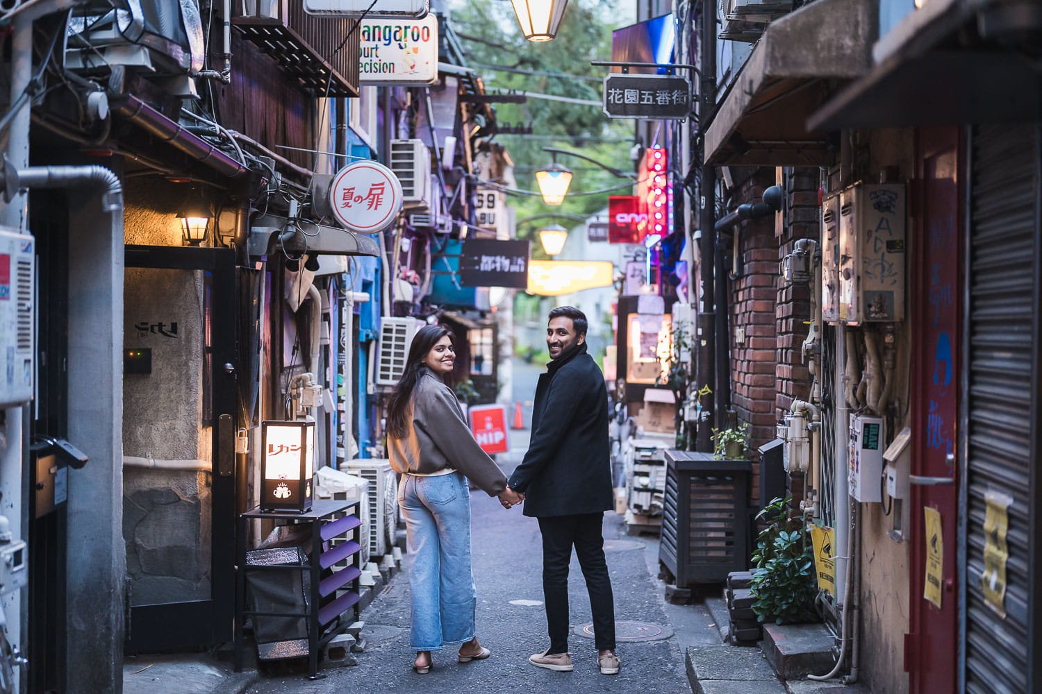 Urban street of a couple strolling thru a hidden alley in Shinjuku Golden Gai