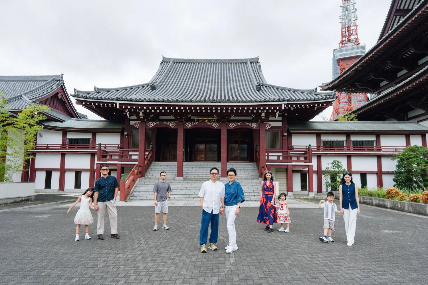 Multi-generation family photoshoot at Zojoji Temple with Tokyo Tower in the background on a cloudy day