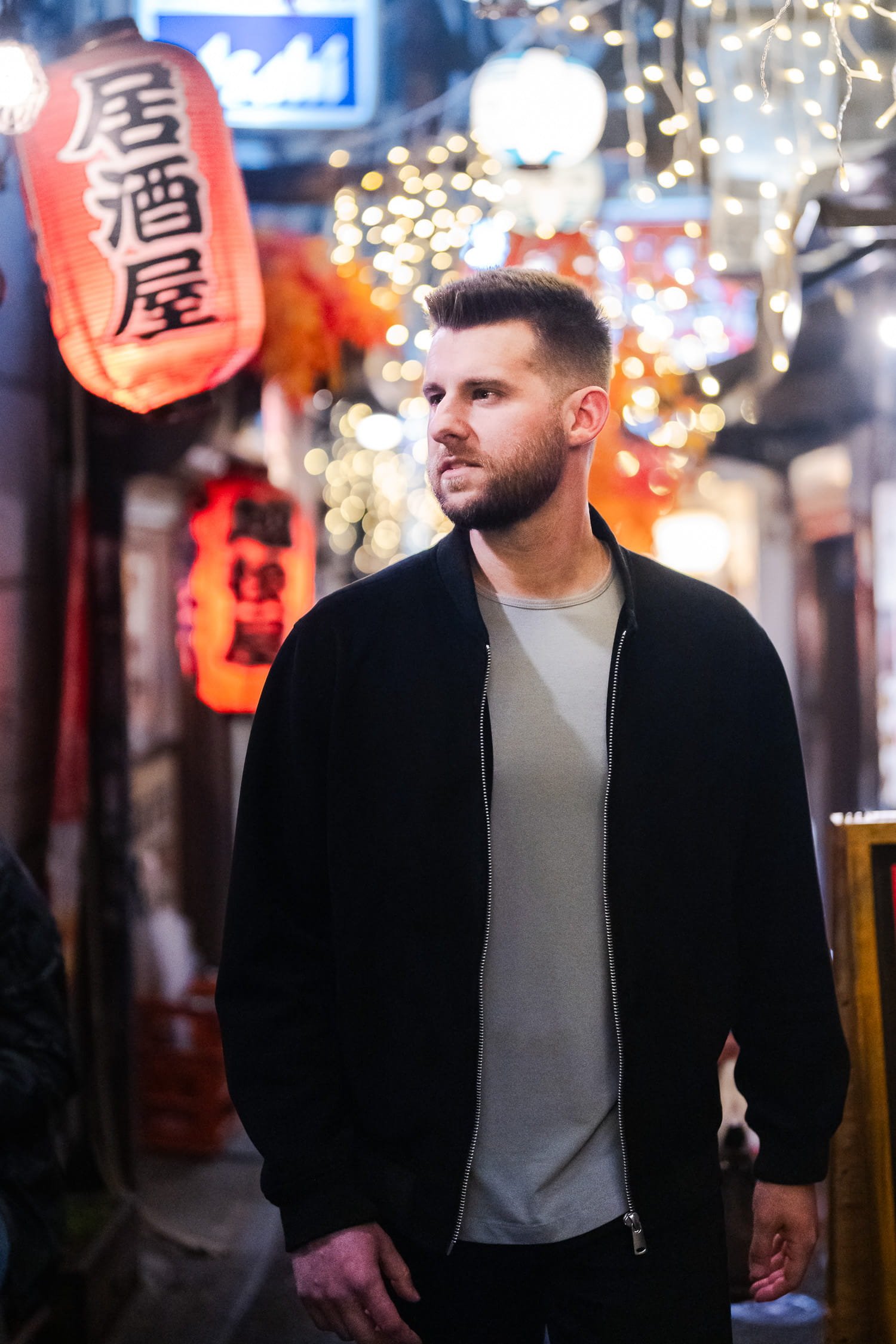 American traveler strolling thru a lantern-alley in Shinjuku Omoide Yokocho AKA Memory Lane