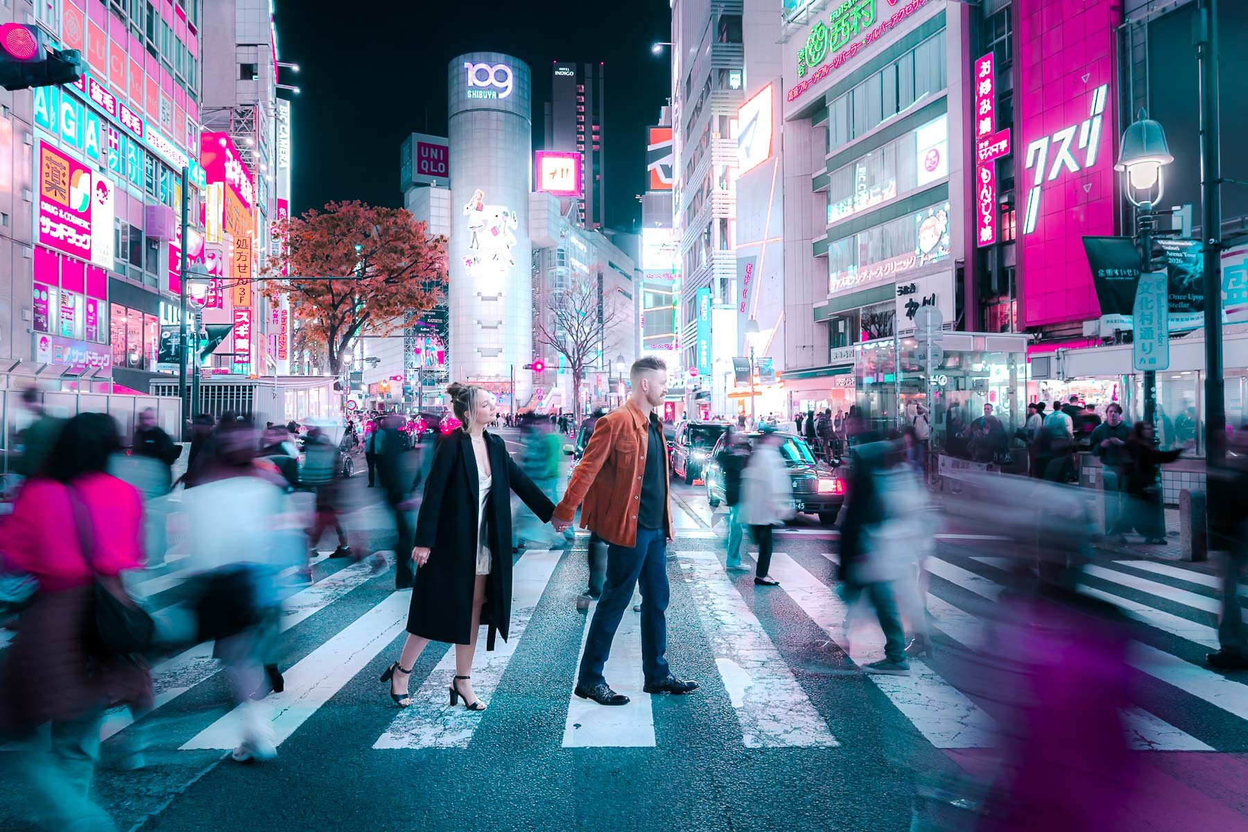 Couple holding hands at Shibuya Crossing, Tokyo, in a neon cyberpunk-style photoshoot