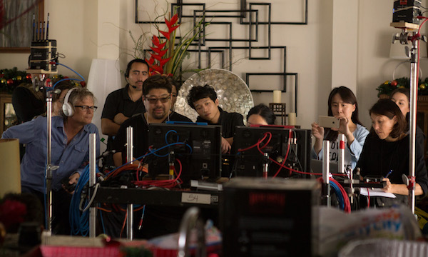 DIRECTOR JONATHAN LIM (THIRD FROM LEFT, WEARING GLASSES) REVIEWS A TAKE WITH MEMBERS OF THE CREW DURING THE MAKING OF "PALI ROAD," THE FILM FESTIVAL'S CLOSING NIGHT PRESENTATION. (PHOTO: COURTESY THE FILMMAKER)