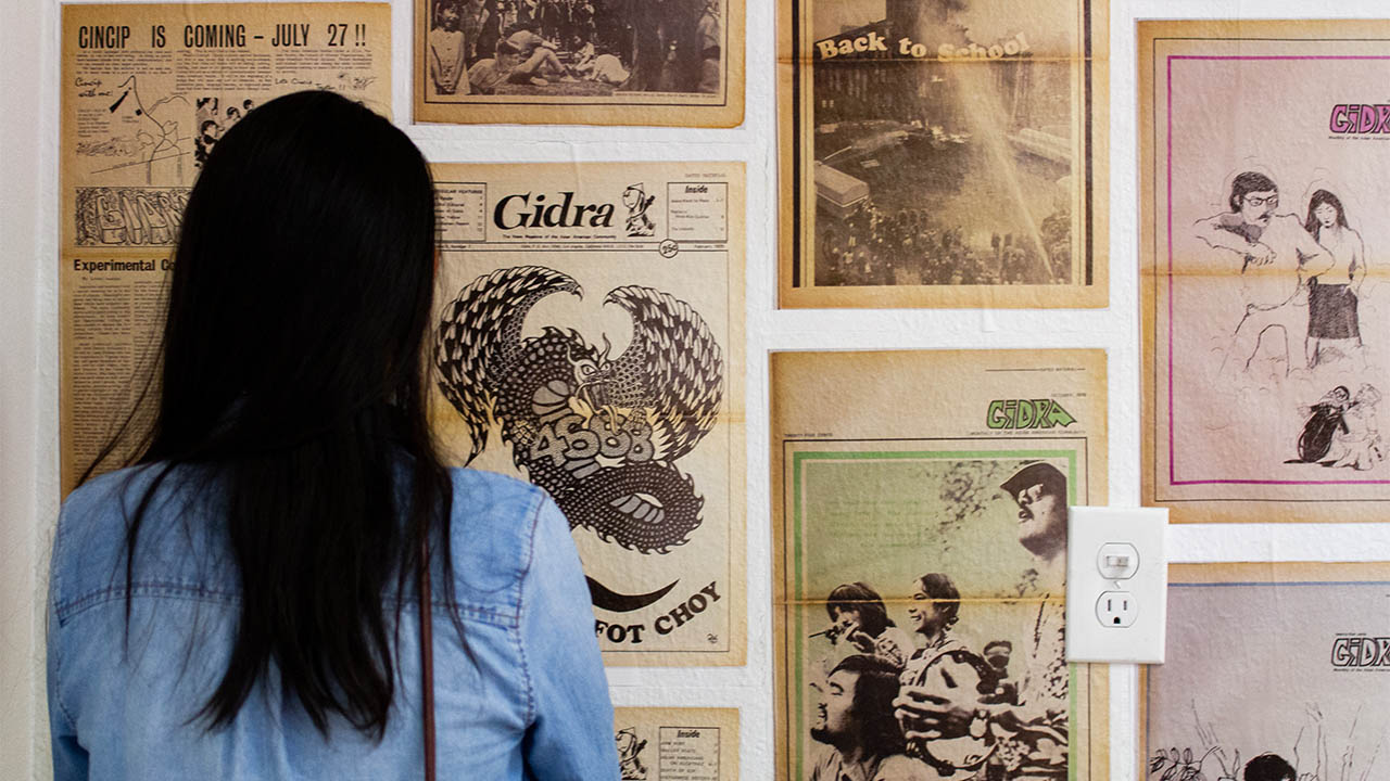 A visitor to “centering the masses” views the gidra “wall of tribute” at 341fsn. (photo: Josaen Ronquillo/visual communications photographic archive)