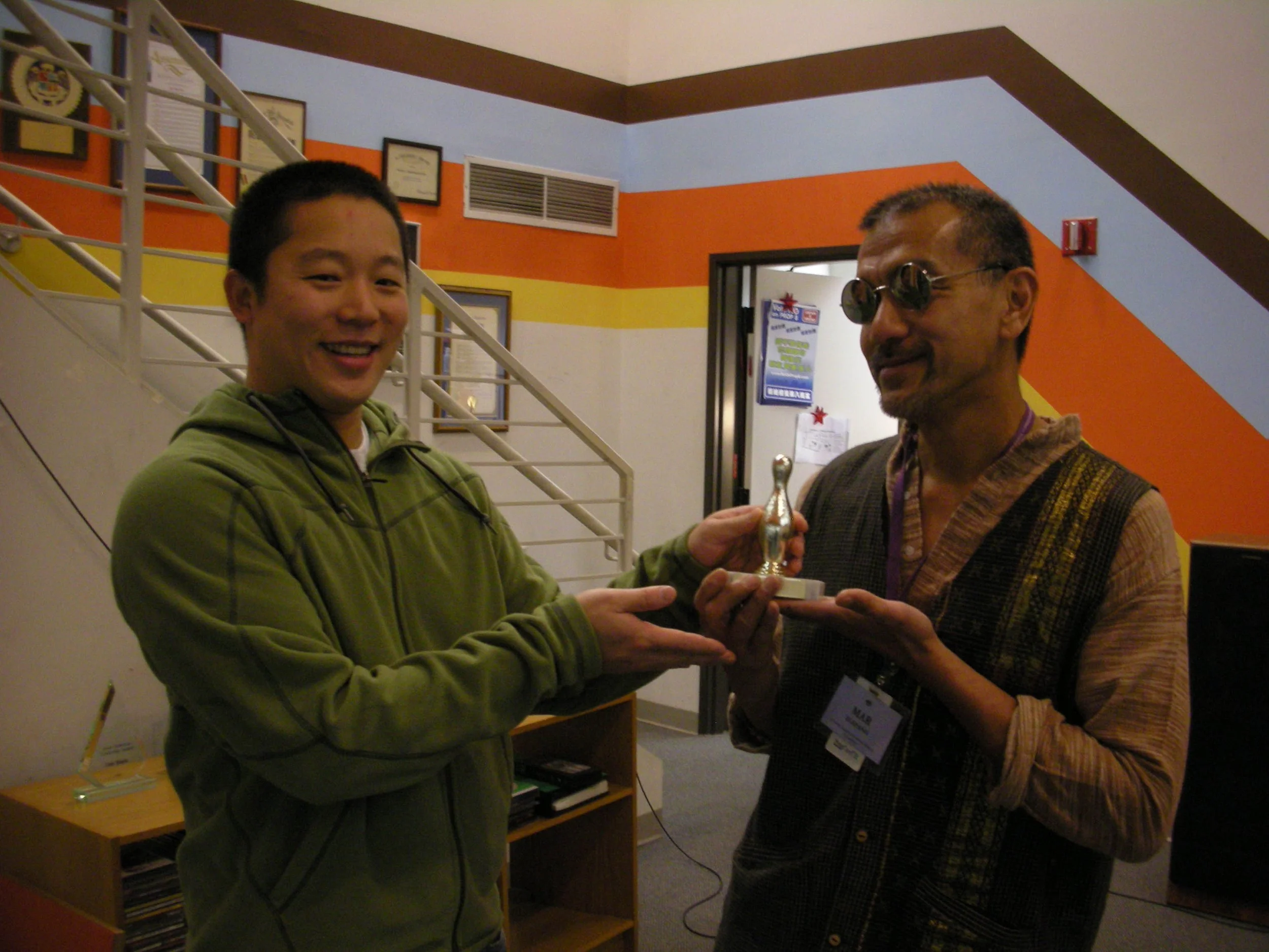 Jeff Liu presenting an award to Mar Elepano during his visit to Visual Communications