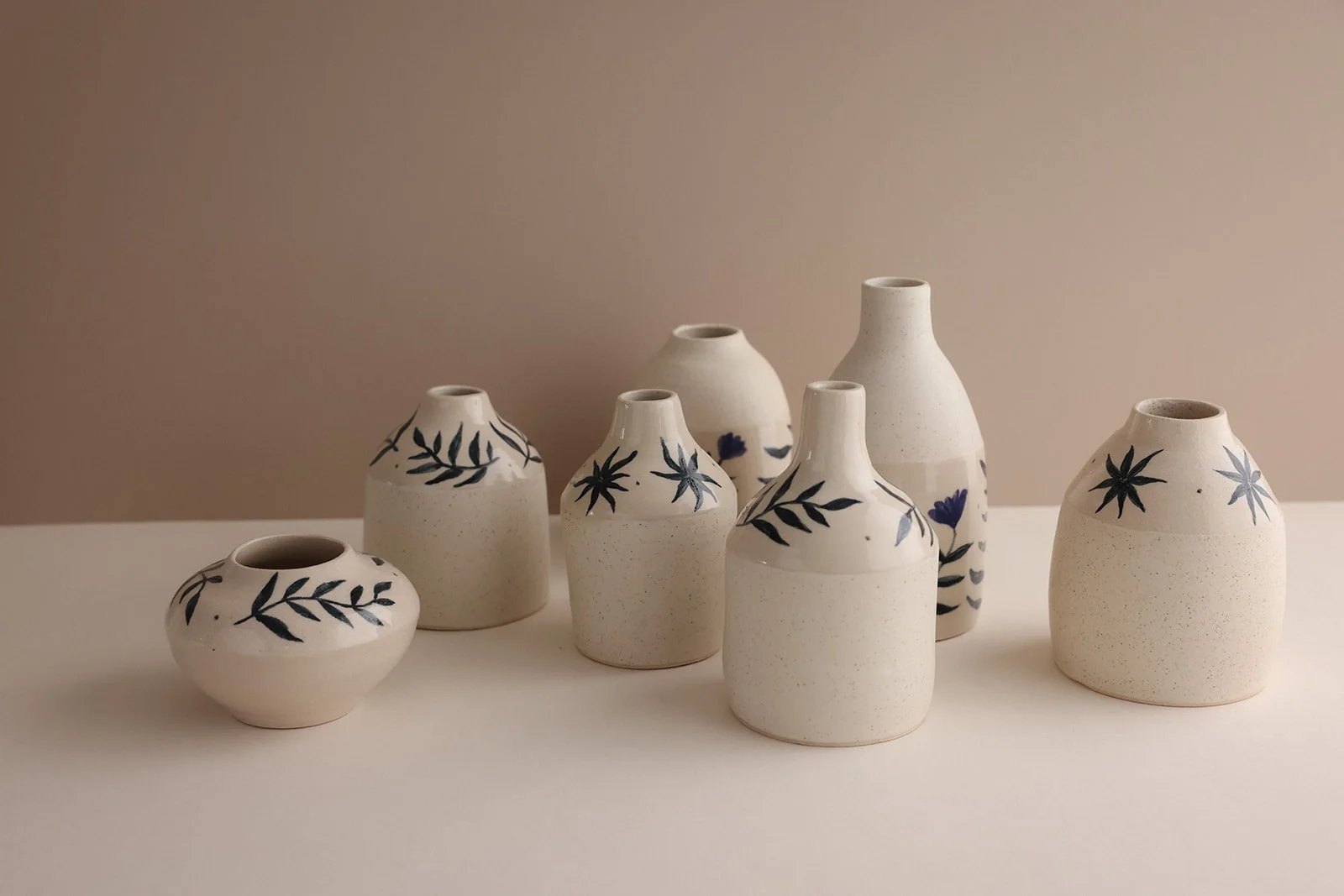 Wheel-thrown stoneware vases with botanical illustrations.