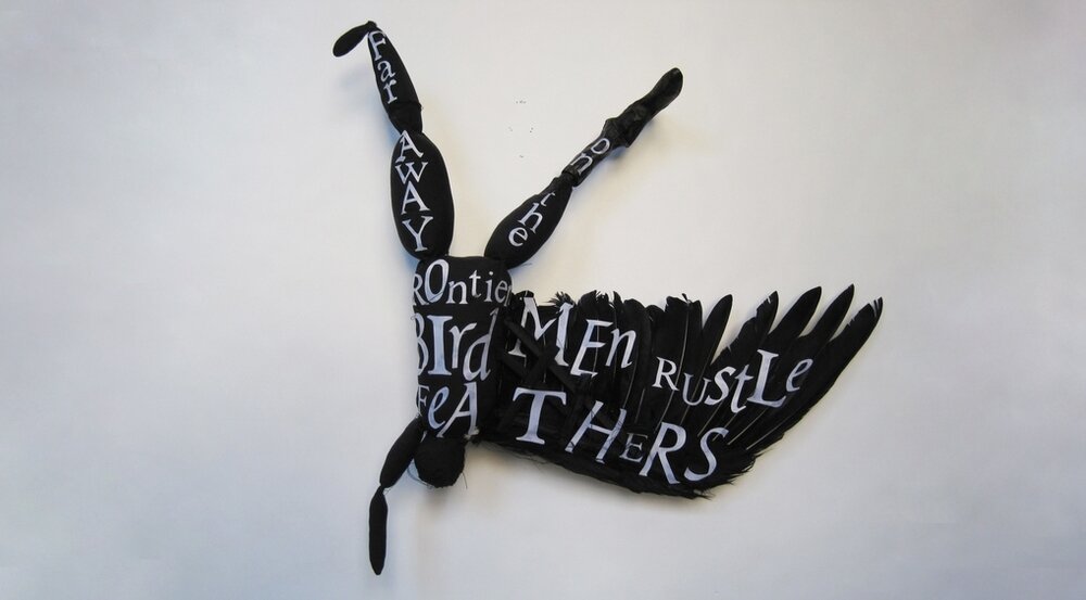 FLYING BLACK BIRD MAN WITH WHITE LETTERS