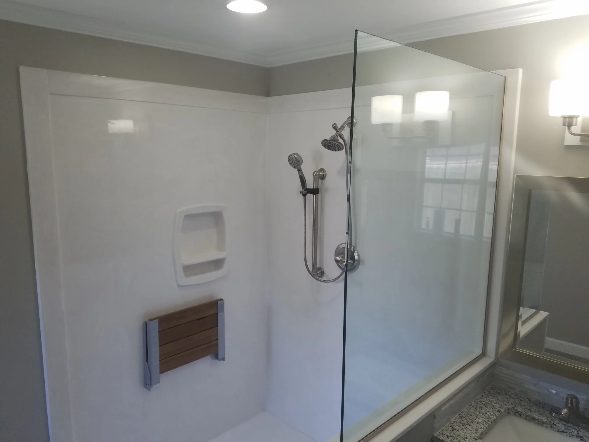 Roll-in Shower with bench and hand-held shower head.