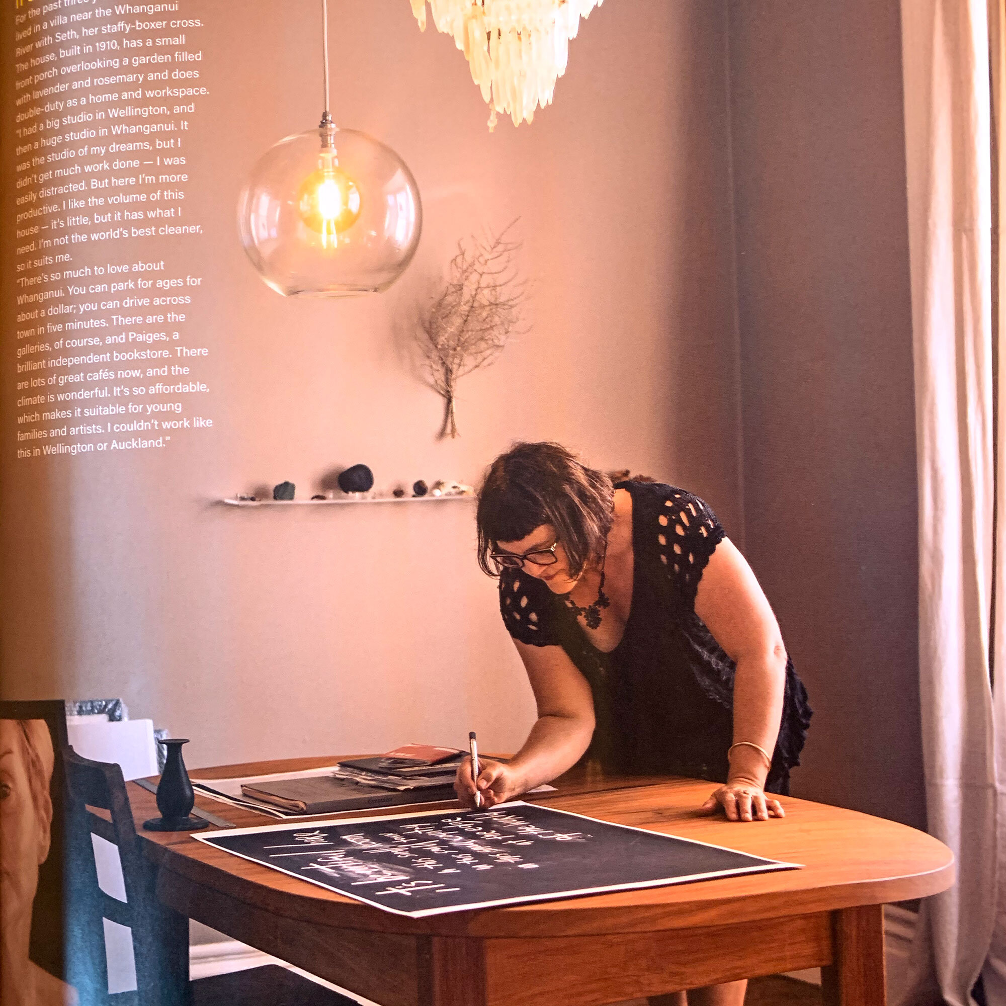  IN MY WORKROOM  Here I am working at my table, doing the overdrawing in pencil I do on every single studioprint of “  it’s beautiful here at the edge  ” that I’ve ever made.  It means every print is unique, is touched by my own hand.  This one’s a size large.  The words read:  It’s beautiful here / in this small room / in this small town / in this small country / at the edge / of the world.  FYI, the edition of this artwork is nearly sold out, so if you love it, I’d suggest getting in quick.  