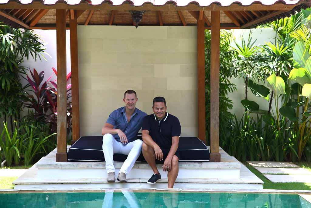 Two men sitting by the pool in a Bali resort