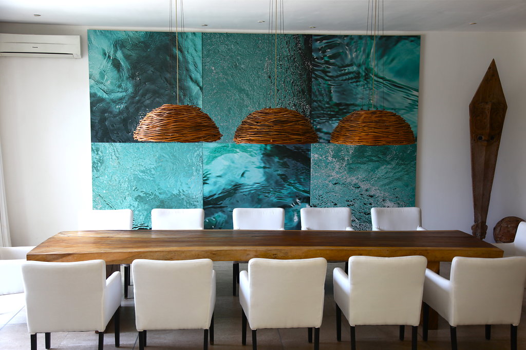 Long wooden table with blue art in on the wall